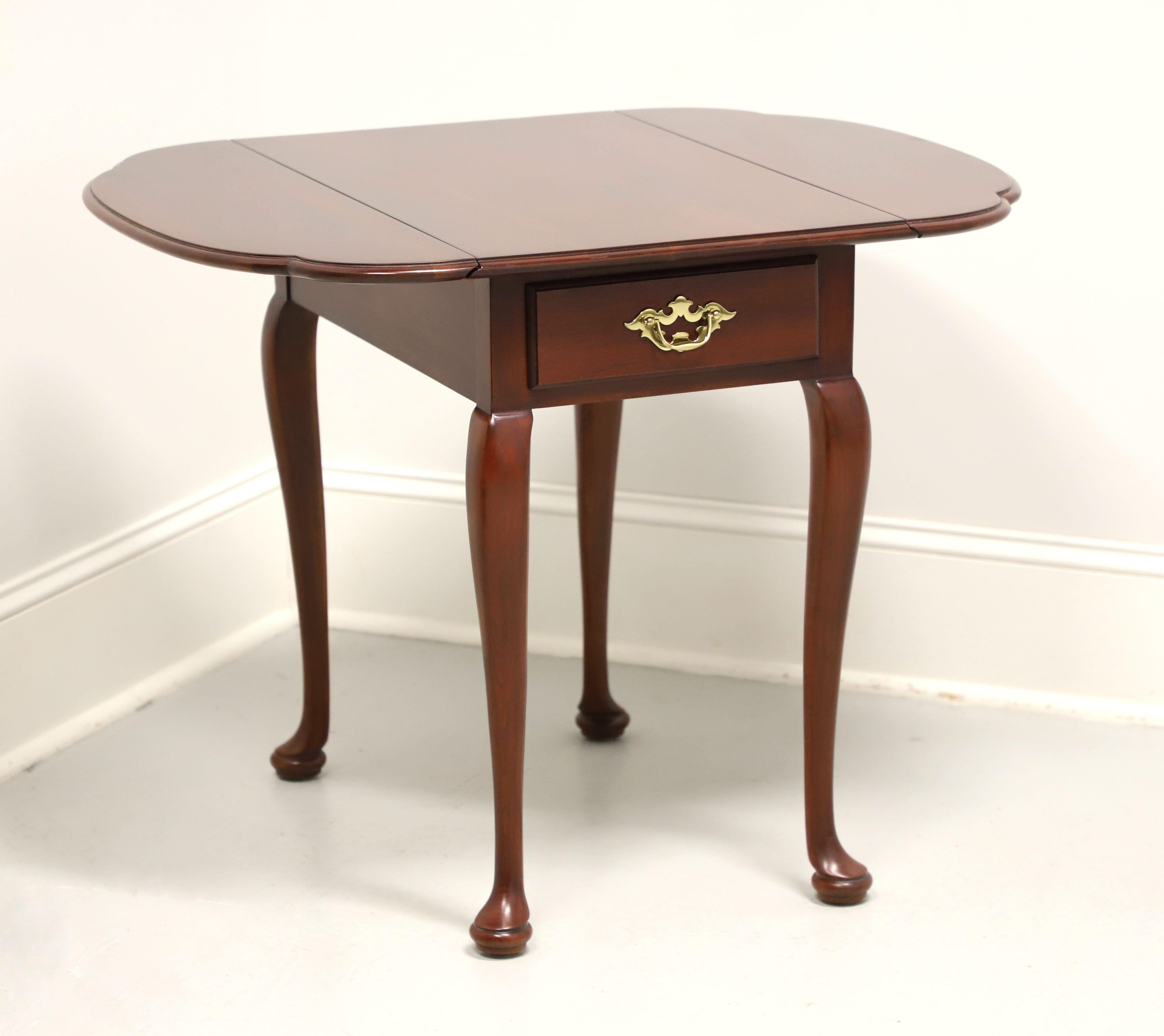 A Queen Anne style drop-leaf side table by Statton Furniture, from their Trutype Americana line. Solid cherry wood with their Centennial finish, brass hardware, bevel edge top, cabriole legs and pad feet. Features rounded edge drop leaves and one