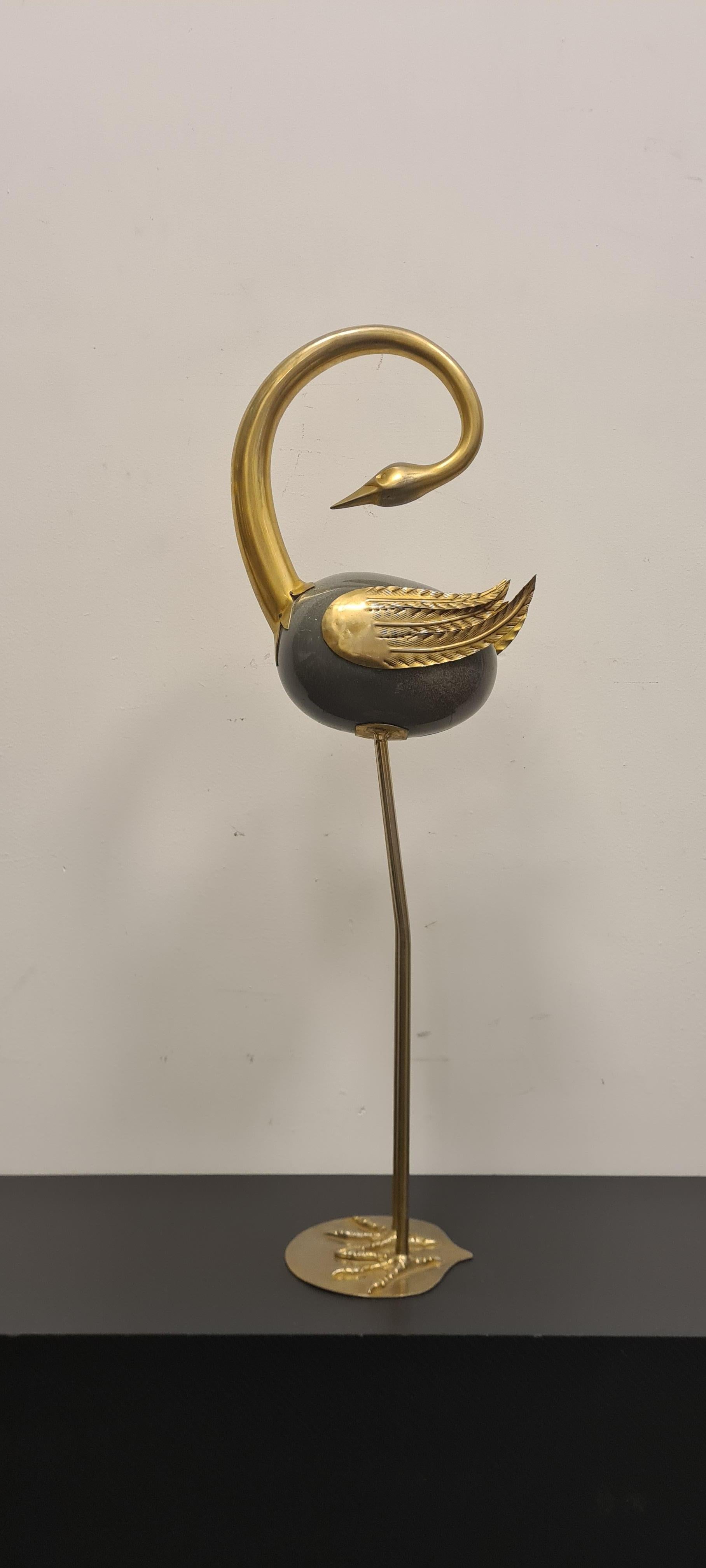 Statue depicting a heron made by Antonio Pavia.

Elegant heron made of lacquered metal and brass.

The heron features a central body made of gray lacquered metal and tulle the remaining parts such as base wings and neck are made of brass.

This