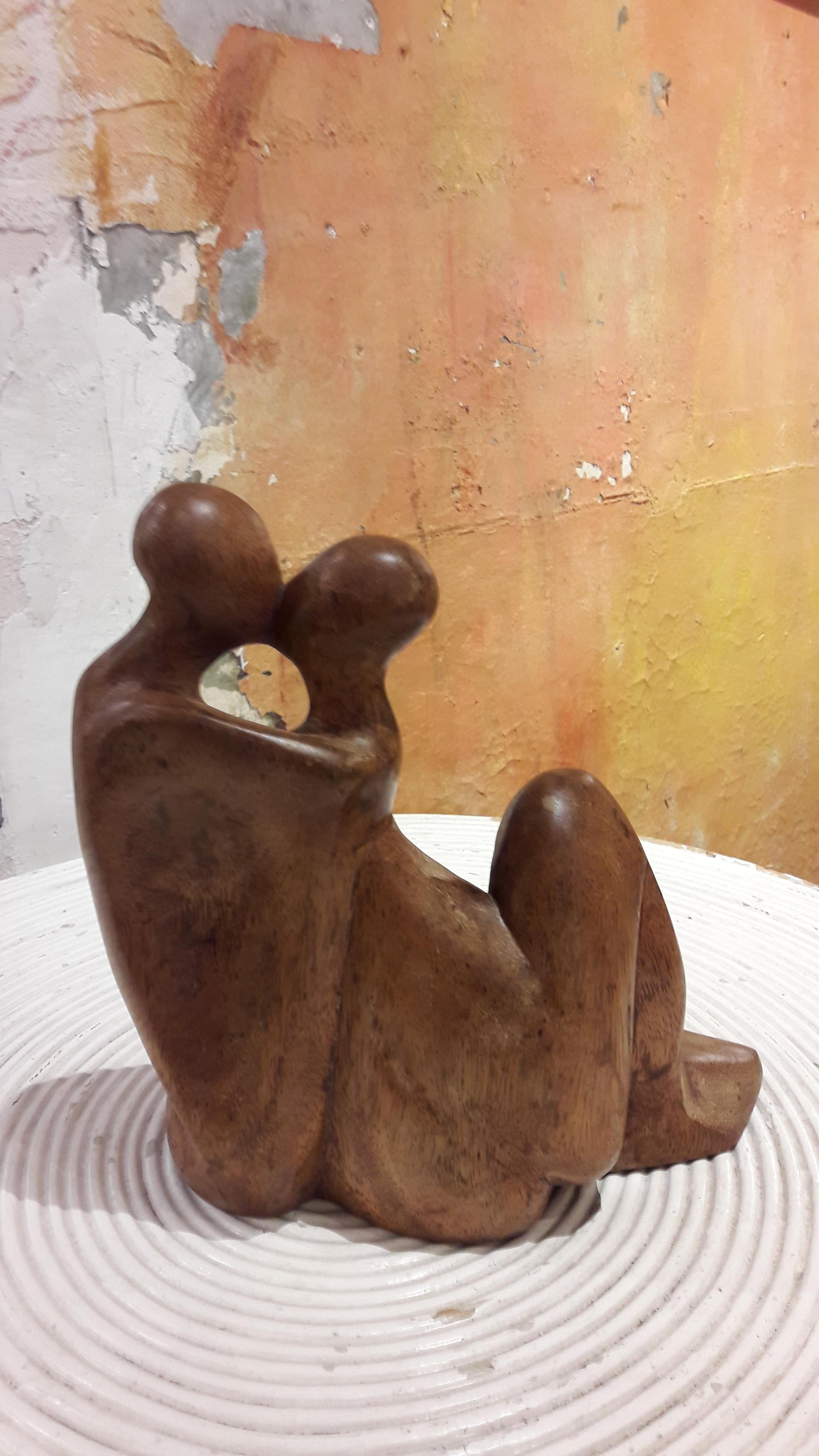 Decorative statue of a kissing couple in teak.