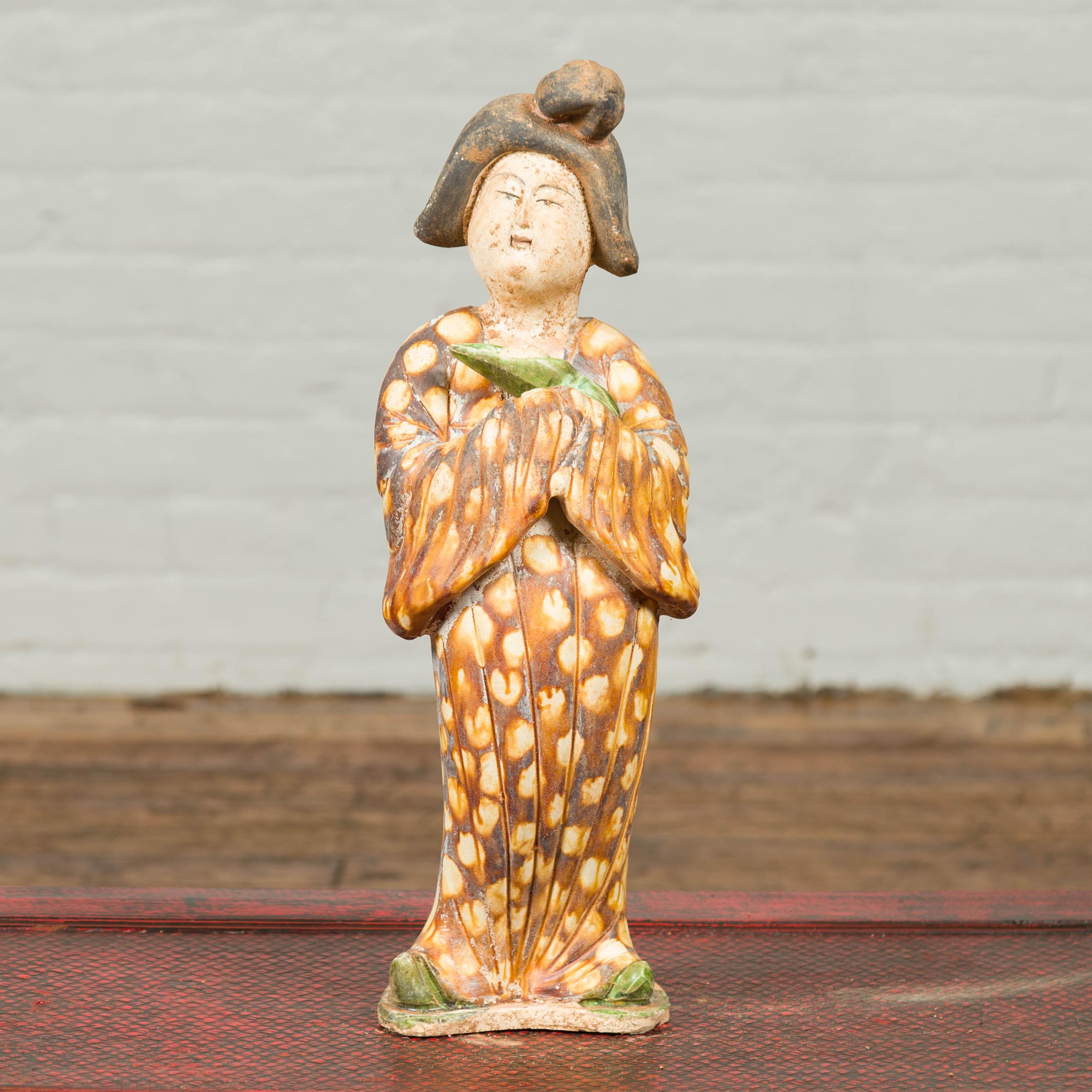 Petite statue chinoise vintage représentant une dame de la cour vêtue d'un kimono brun à motifs géométriques et tenant un bébé emmailloté. Inclinant légèrement la tête sur le côté et portant une coiffure traditionnelle, cette dame de la cour est