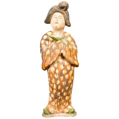 Statue d'une dame de la cour chinoise portant un kimono à motifs bruns et tenant un bébé dans ses bras