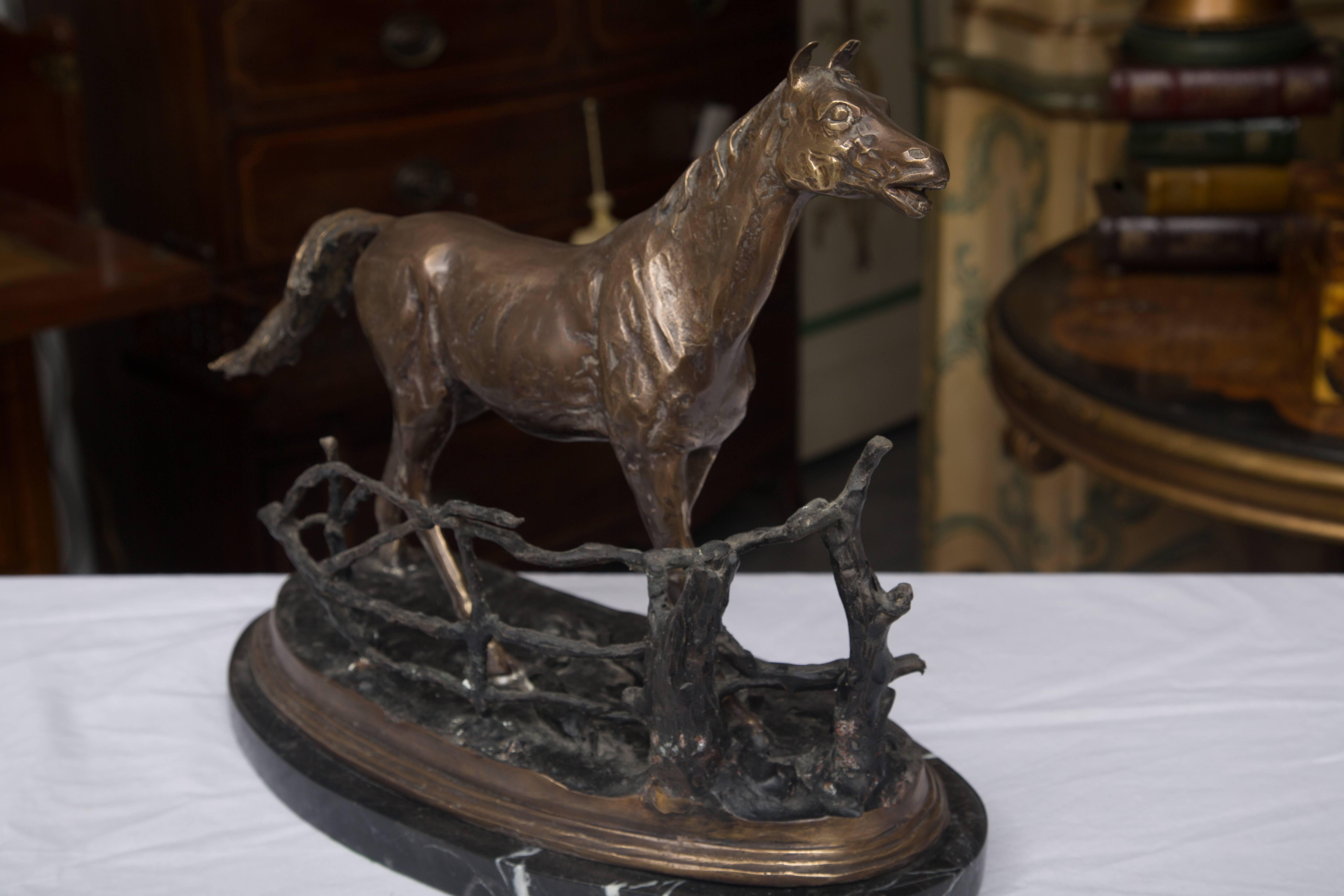 This nicely crafted model of a horse in full pose is situated behind natural fencing and is accented by a conforming marble base, mid-20th century.