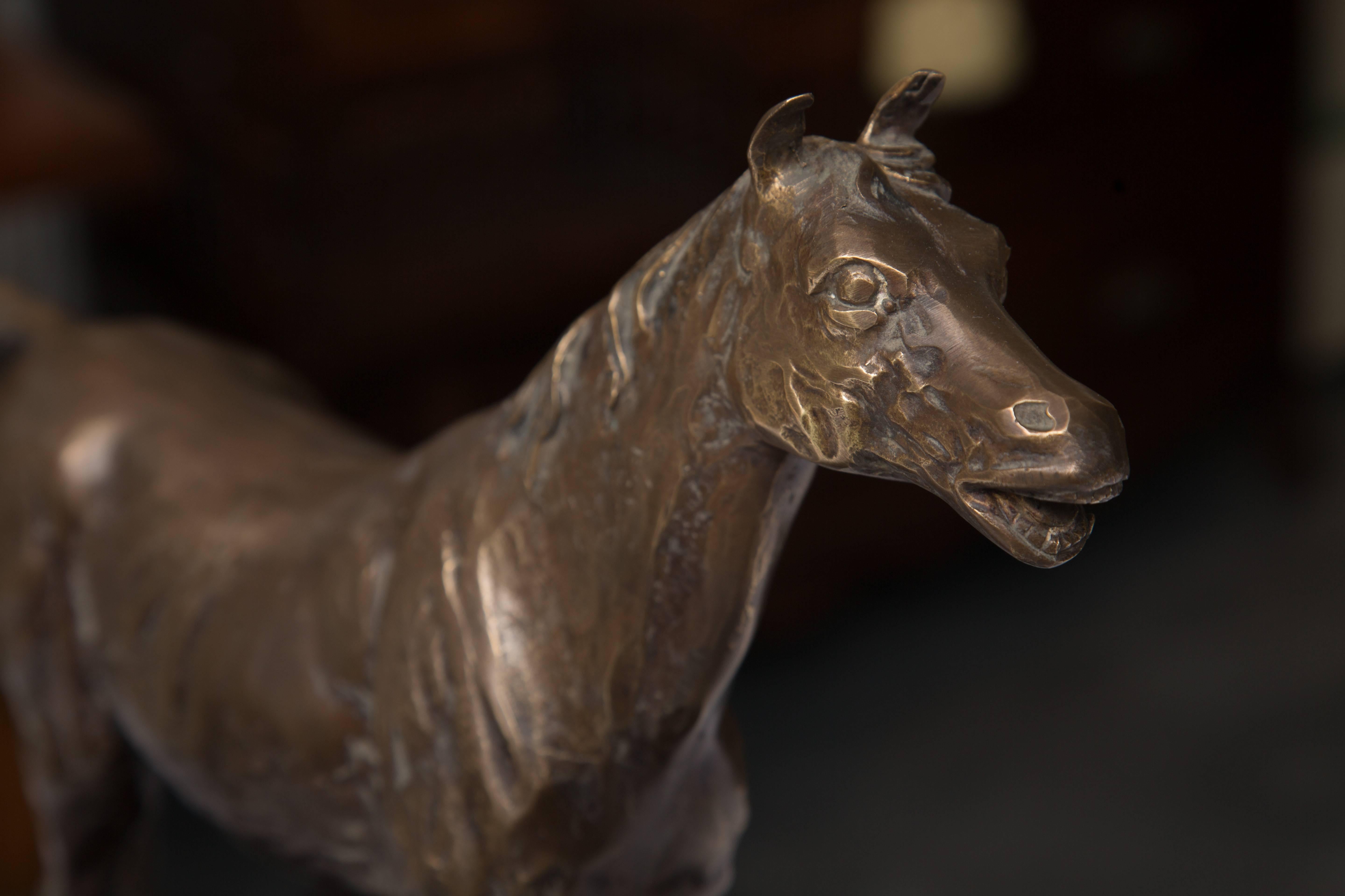 This nicely crafted model of a horse in full pose is situated behind natural fencing and is accented by a conforming marble base, mid-20th century.