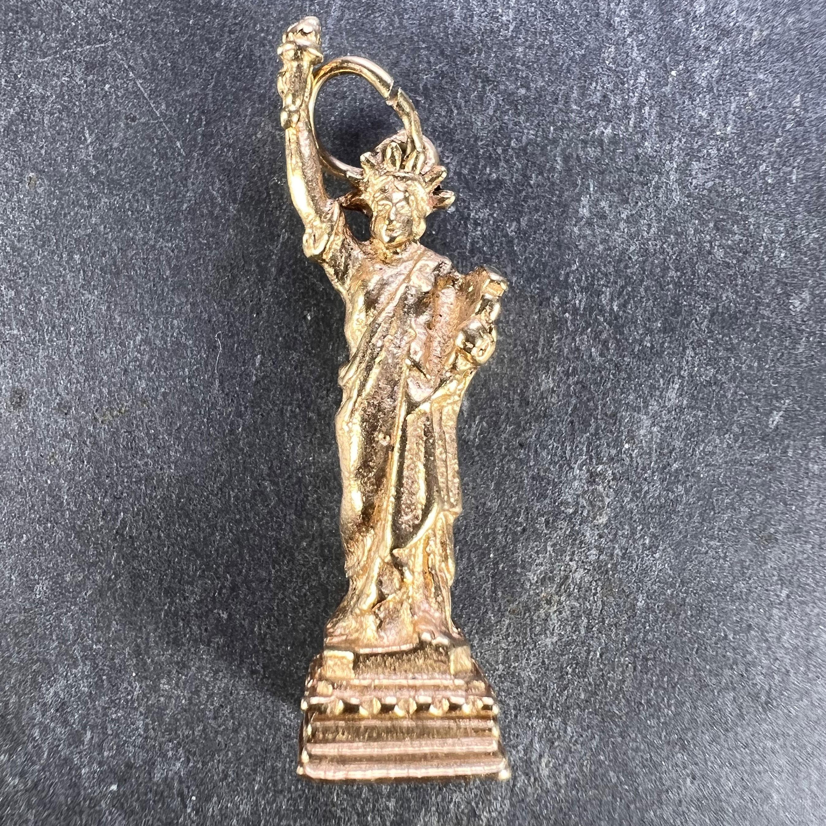 A 14 karat (14K) yellow gold charm pendant designed as the Statue of Liberty in New York. Stamped 14K to the base of the charm with the French import mark for 14 karat gold.

Measurements: 3.1 x 0.85 x 0.85 cm (not including jump ring)
Weight: 5.03