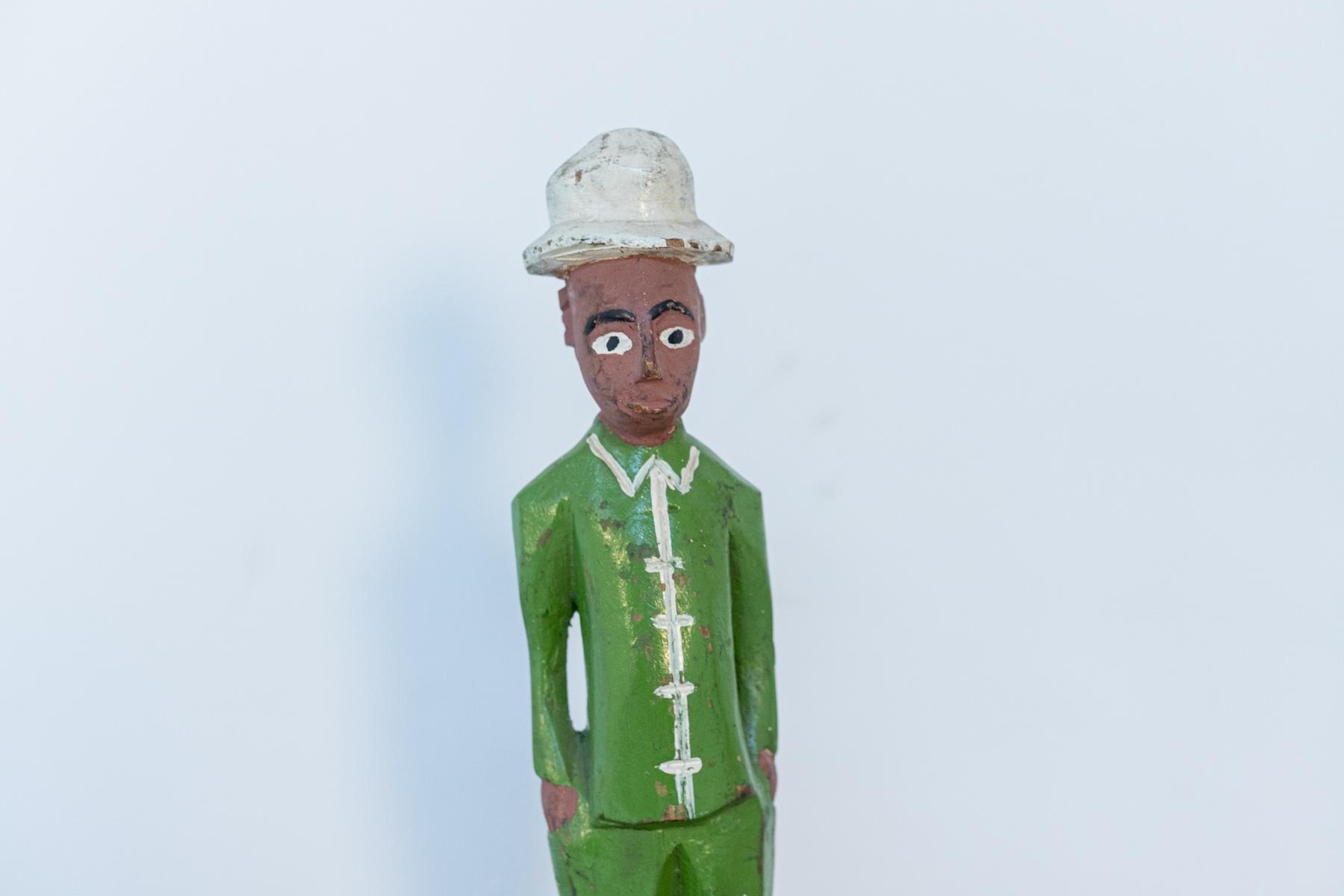 Beautiful painted wood statue from the 50's, belonging to African art.
The statue of a man African art is made entirely of painted wood, depicts a man with his hands in his pockets.
The man is wearing a shiny green jacket, has his hands in his