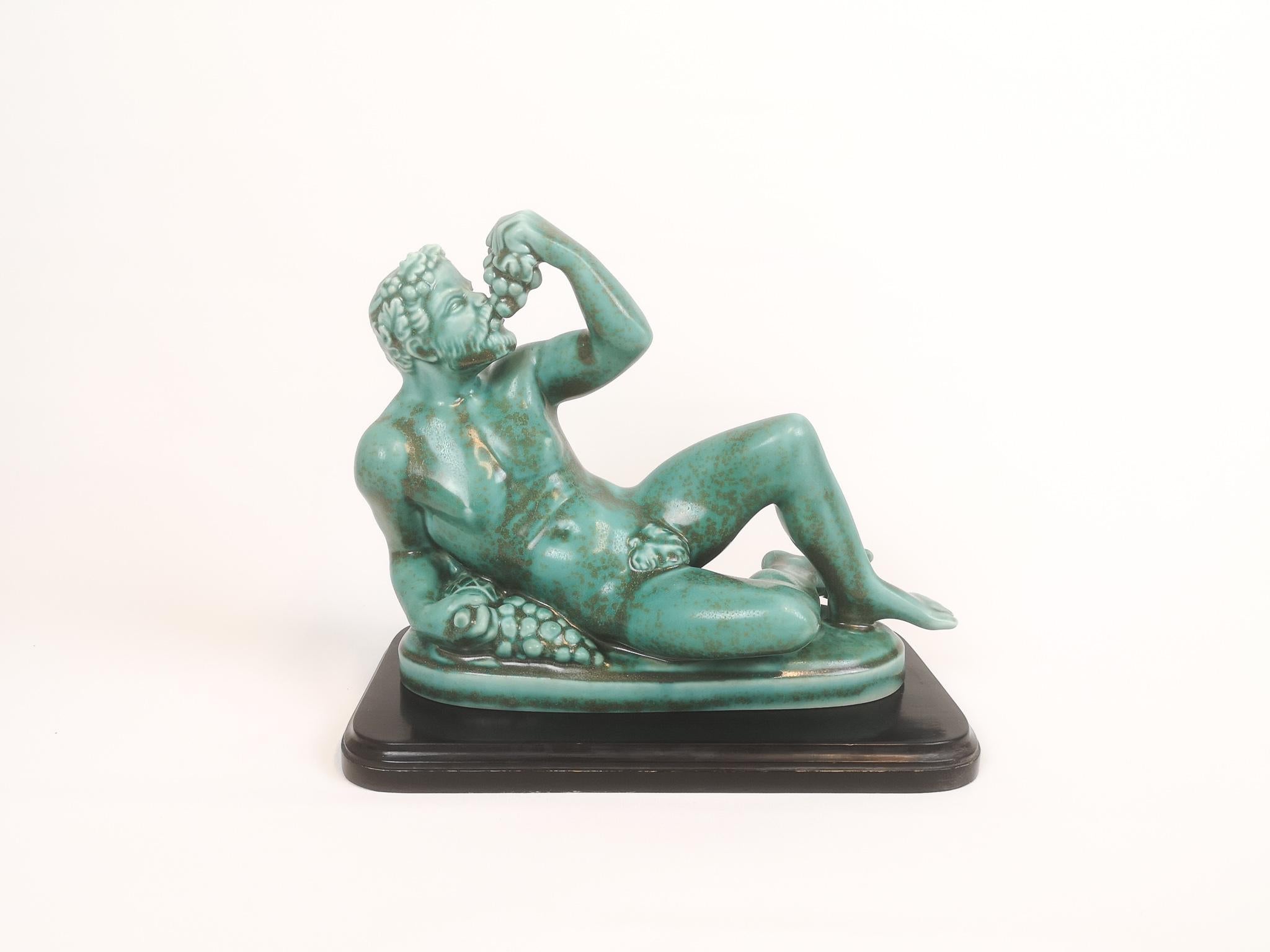 The portrait made as small staty of Bacchus the roman wine god for Rörstrand in 1944, designed by Danish designer Harald Salomon. Bacchus has wonderful detailed lines and the green glaze gives life to the sculpture. 

Very good