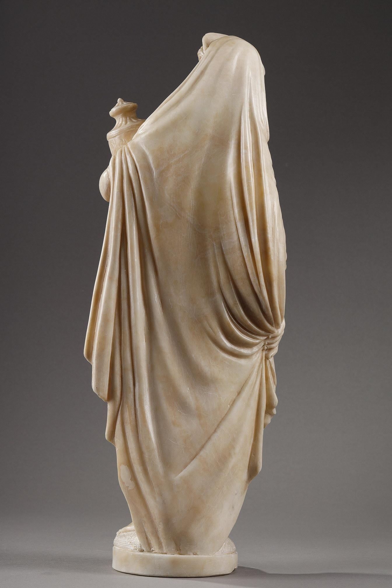 Delicate alabaster statuette representing Pandora, after James Pradier. She is draped in a long veil starting from her tiara which hides half of her body leaving one of her breasts visible . The fine sculptural work gives a great plasticity to the