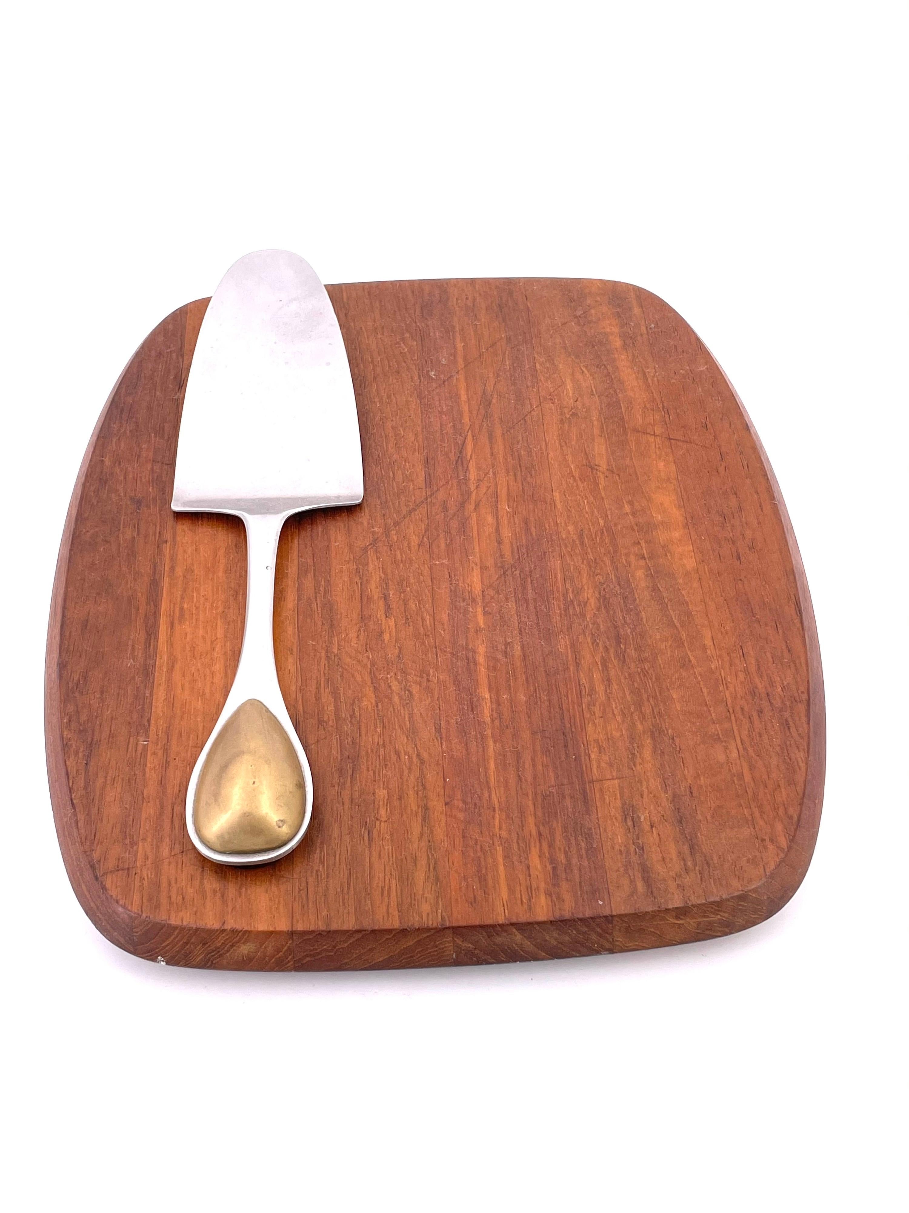 A pristine solid teak cheese board with the cutter designed by Vivianna Torun for Dansk, circa 1960s. The piece is in great condition with what appears to be minimal use and has been cleaned and oiled. #1160.