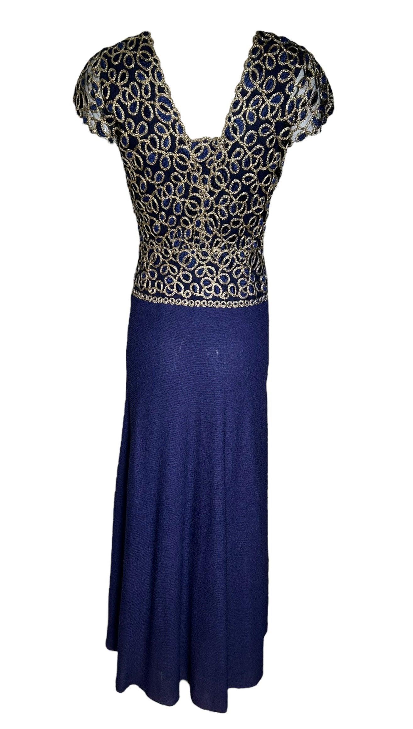 Eleganza con questo abito in crepe di seta Stavropoulos Navy. Il lussuoso e leggero tessuto in crepe di seta si drappeggia magnificamente, mentre il profondo collo a V e le chiusure a scatto aggiungono un tocco di fascino. Ricamo in oro metallizzato