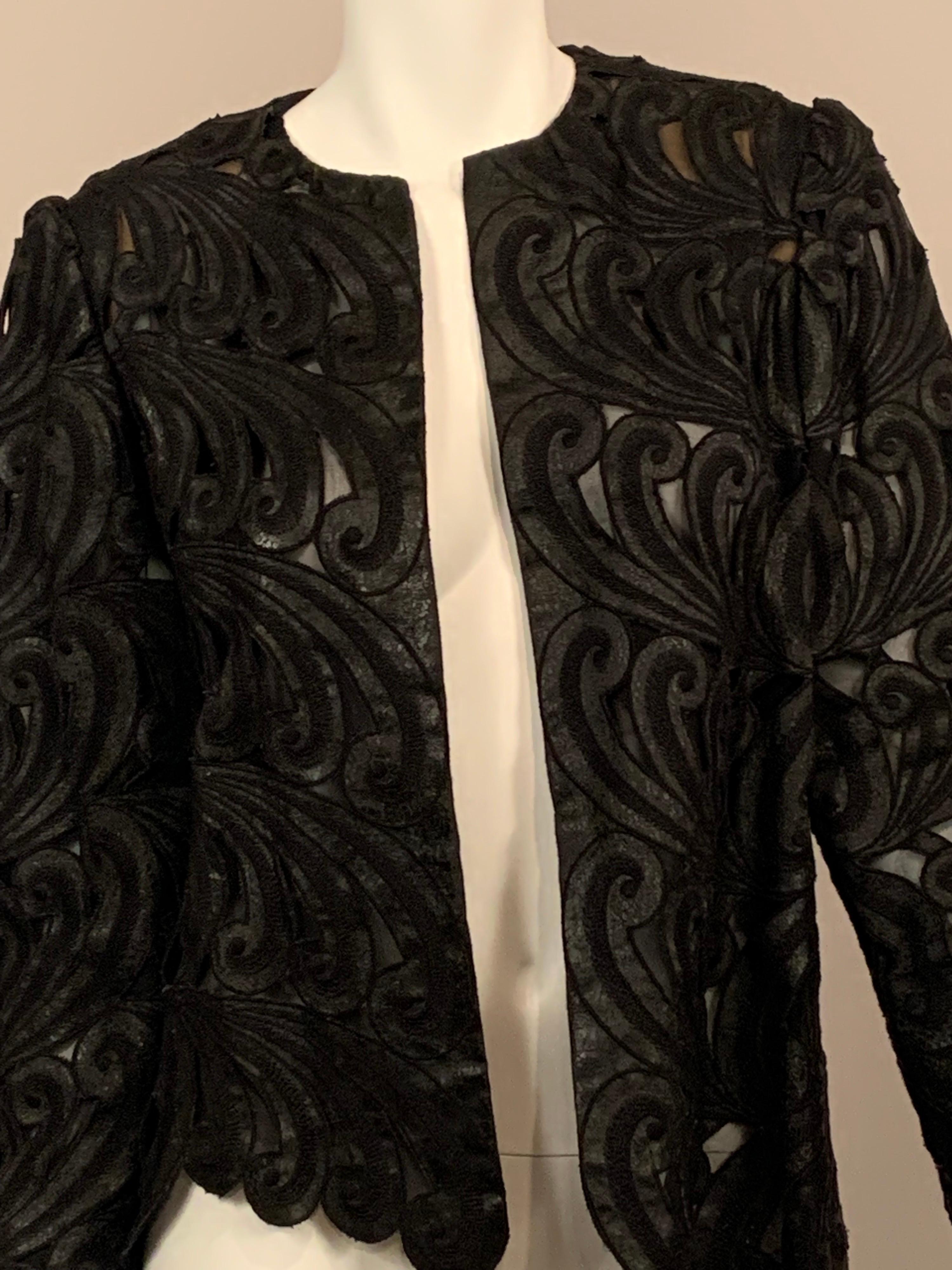 Comma shaped leather motifs are embroidered and distressed and they swirl in opposing directions against a background of sheer black silk chiffon.   The jacket is collarless and there no closures, just an easy piece to slip into. 
There are small