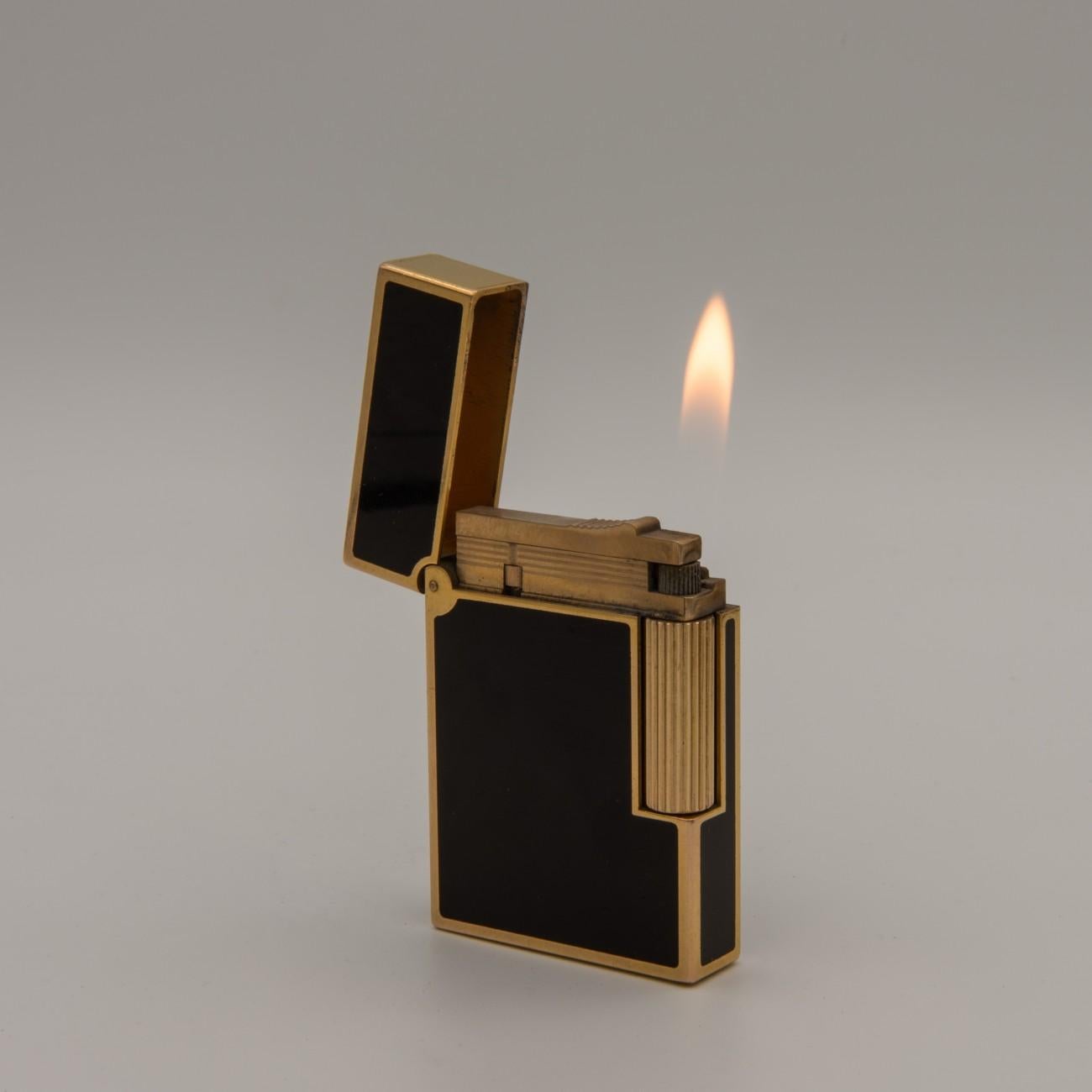 Fine yellow gold-plated S. T. Dupont Ligne 2 gas pocket lighter with beautiful black lacquer inlay, circa 1985. Marked on the base ’S.T Dupont - Paris - Made in France - with serial no. and the Dupont makers mark. In good condition, serviced and in