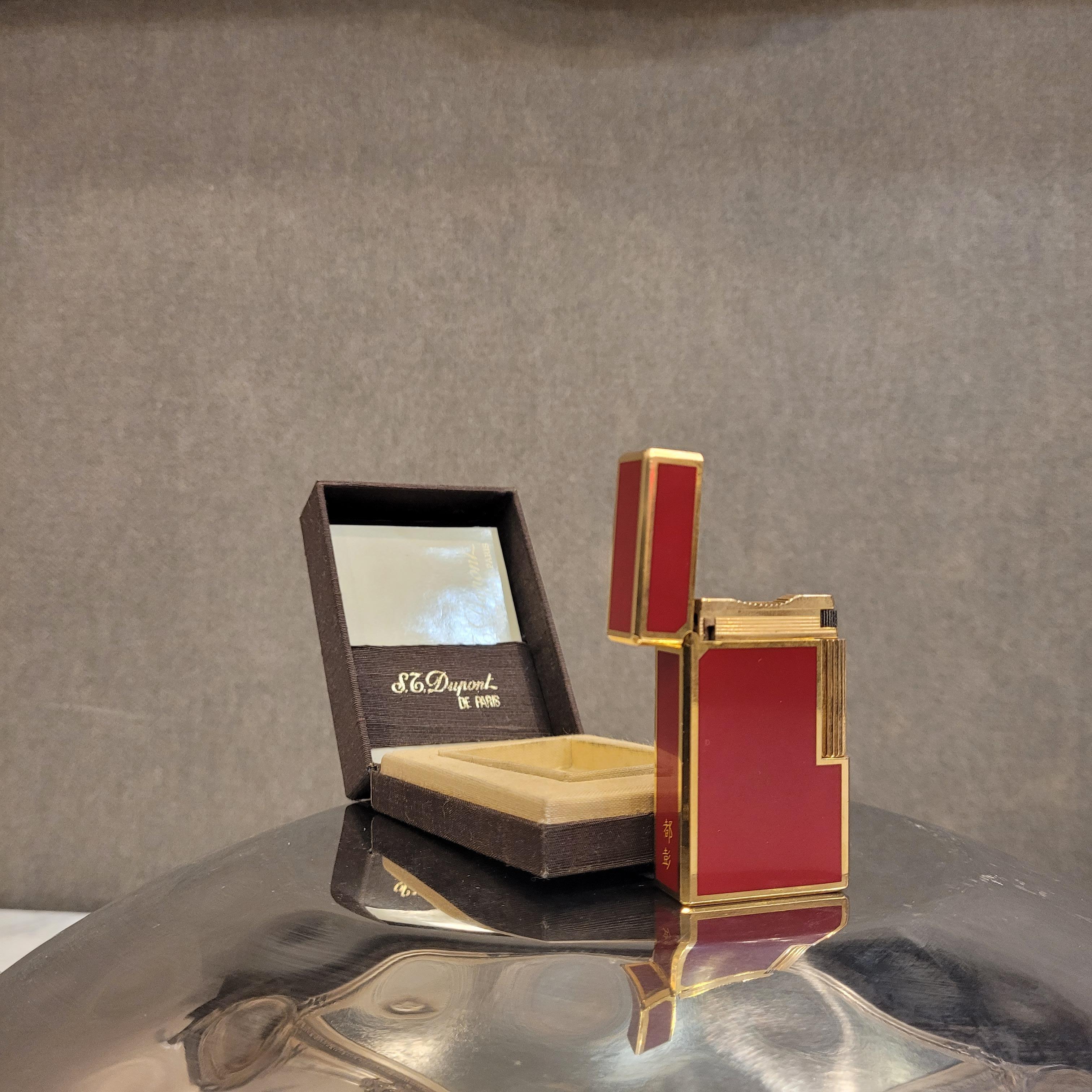 

   
Luxury lighter from the prestigious S.T. Dupont, plated in yellow gold and decorated in authentic Chinese red lacquer, framed between gold profiles. It is engraved with initials (E.E). Its design is a timeless icon among high-end lighters. On