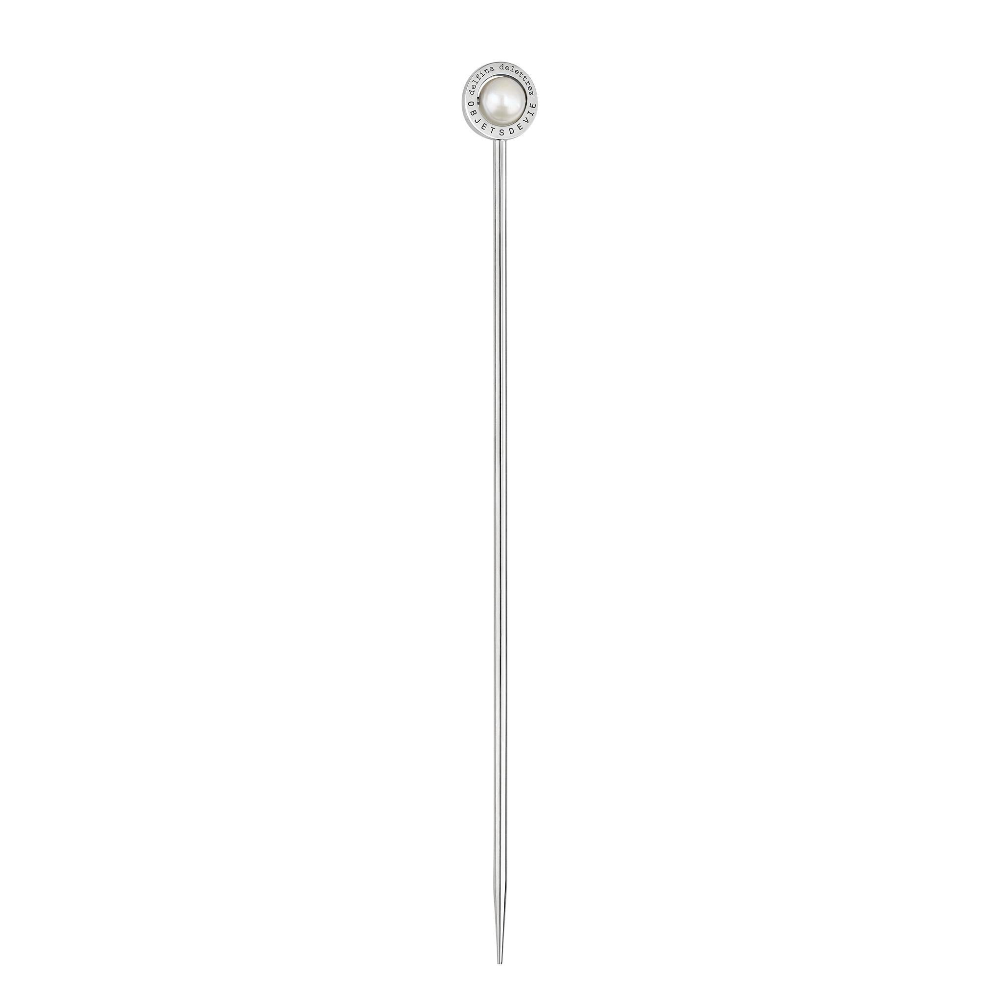 Der Stecco 925 Cocktailstab ist eine 11,5 cm lange Nadel aus Sterlingsilber, die mit einem flachen Silberring versehen ist, der entweder eine sich drehende Perle, einen grünen Achat oder eine blaue oder rosa Chalcedonkugel einrahmt. Zum Aufspießen