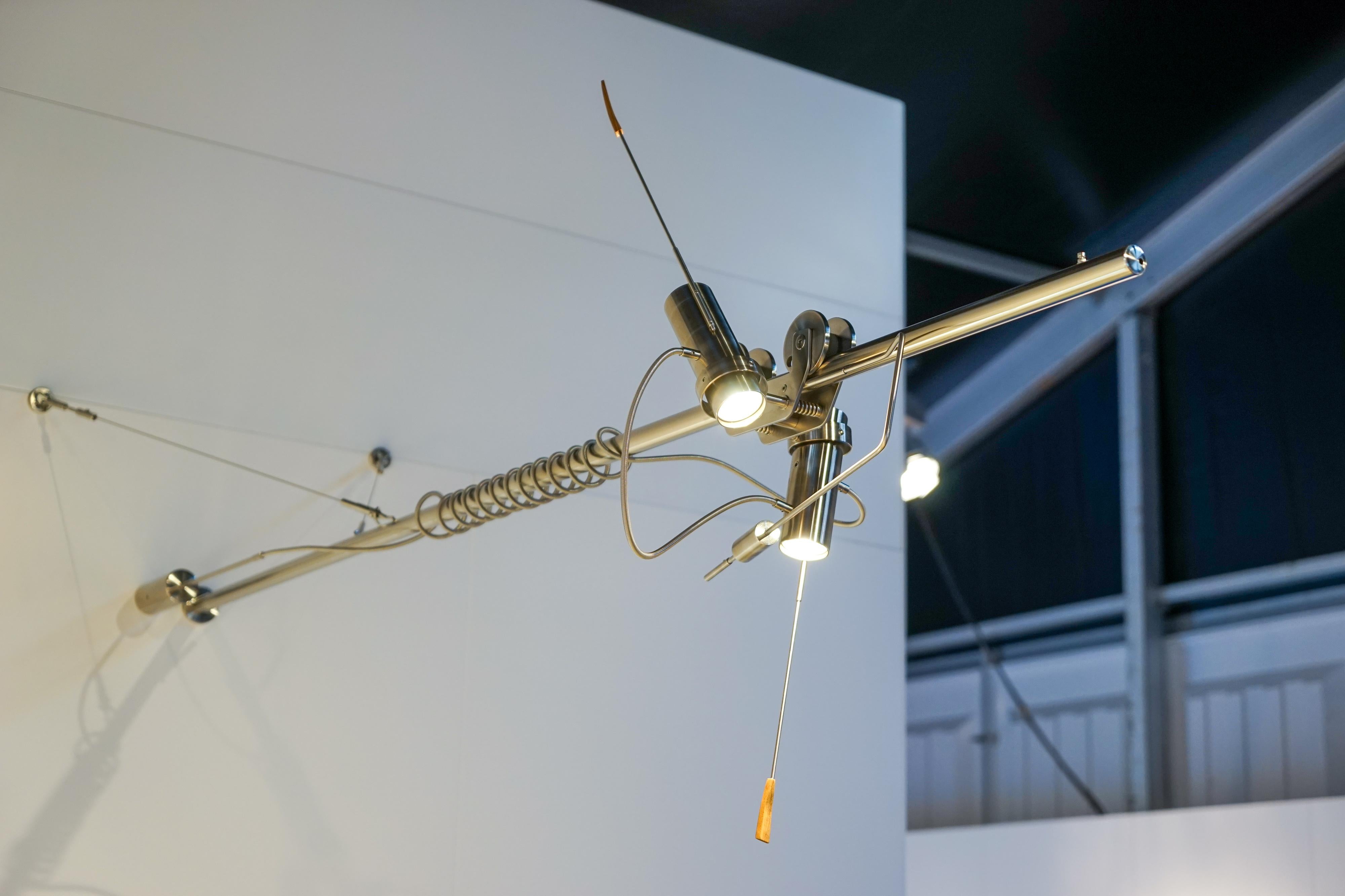 This sculptural piece from Polish studio, Szostak Atelier, features a 2-meter-long arm crafted from premium stainless steel, showcasing elements of Industrial design. The spotlights, positioned on a mobile bogie, offer versatile illumination with