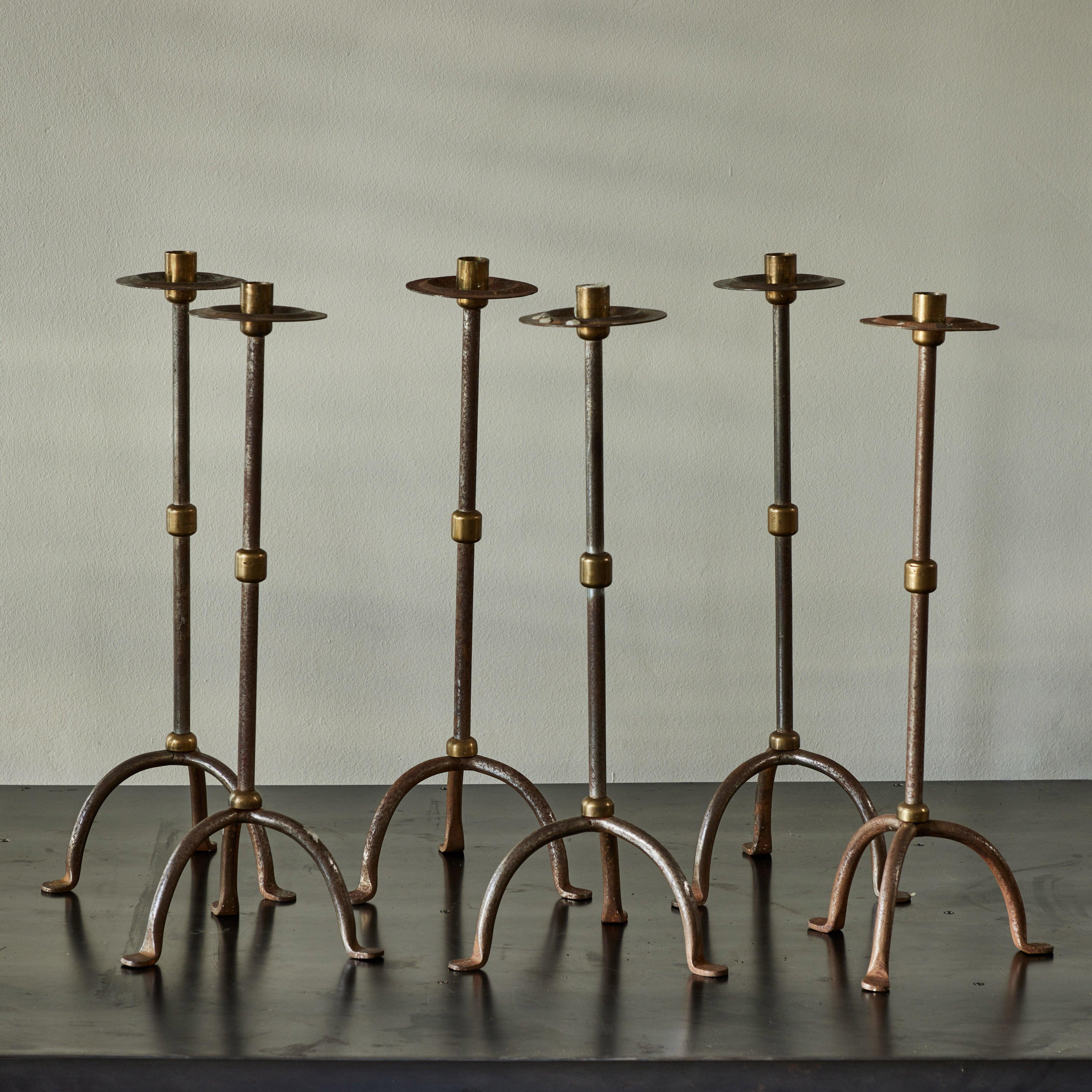 Late 19th-century English steel and brass candlesticks in the Arts & Crafts style. Delicate yet dramatic, these candlesticks add height and a pleasing linearity to any space. Priced in pairs. (Three pairs available).

England, circa
