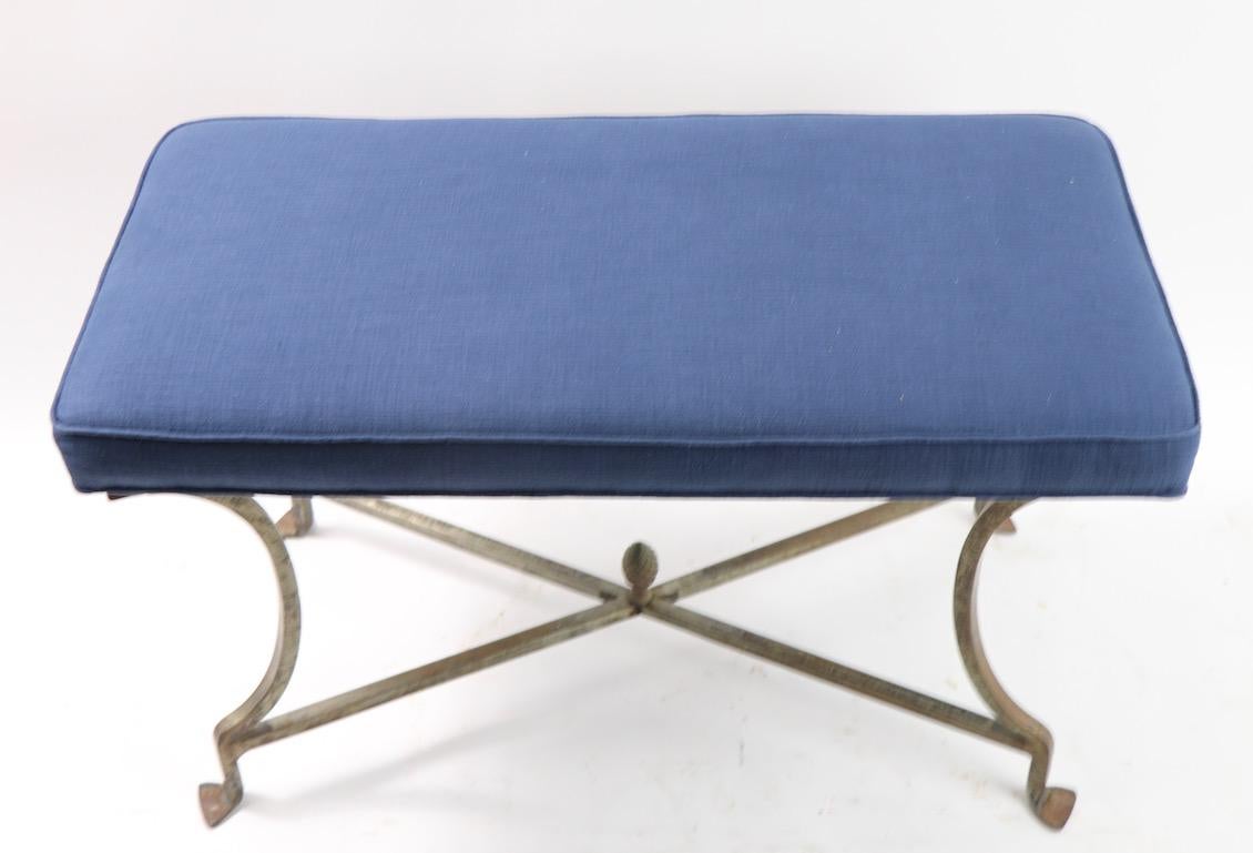 Wonderful decorative bench having a squared steel frame with a brass acorn finial, and newly upholstered top. This diminutive seat can function as a bench, stool, ottoman or pouf. Very well crafted, and in very good condition, metal shows some