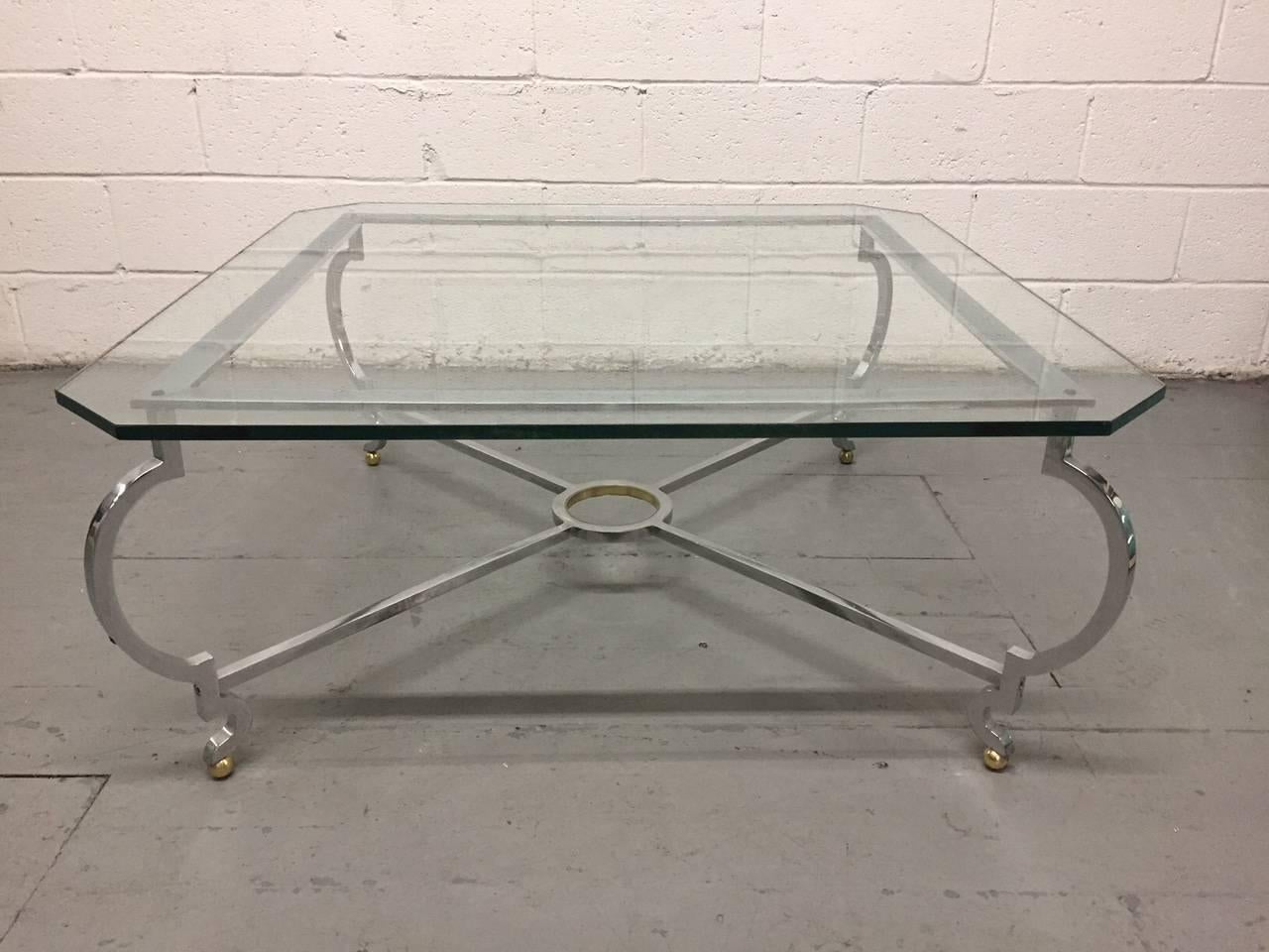Polished steel and brass coffee table manner of Jansen. Stretcher has curved legs with brass ball feet.
   