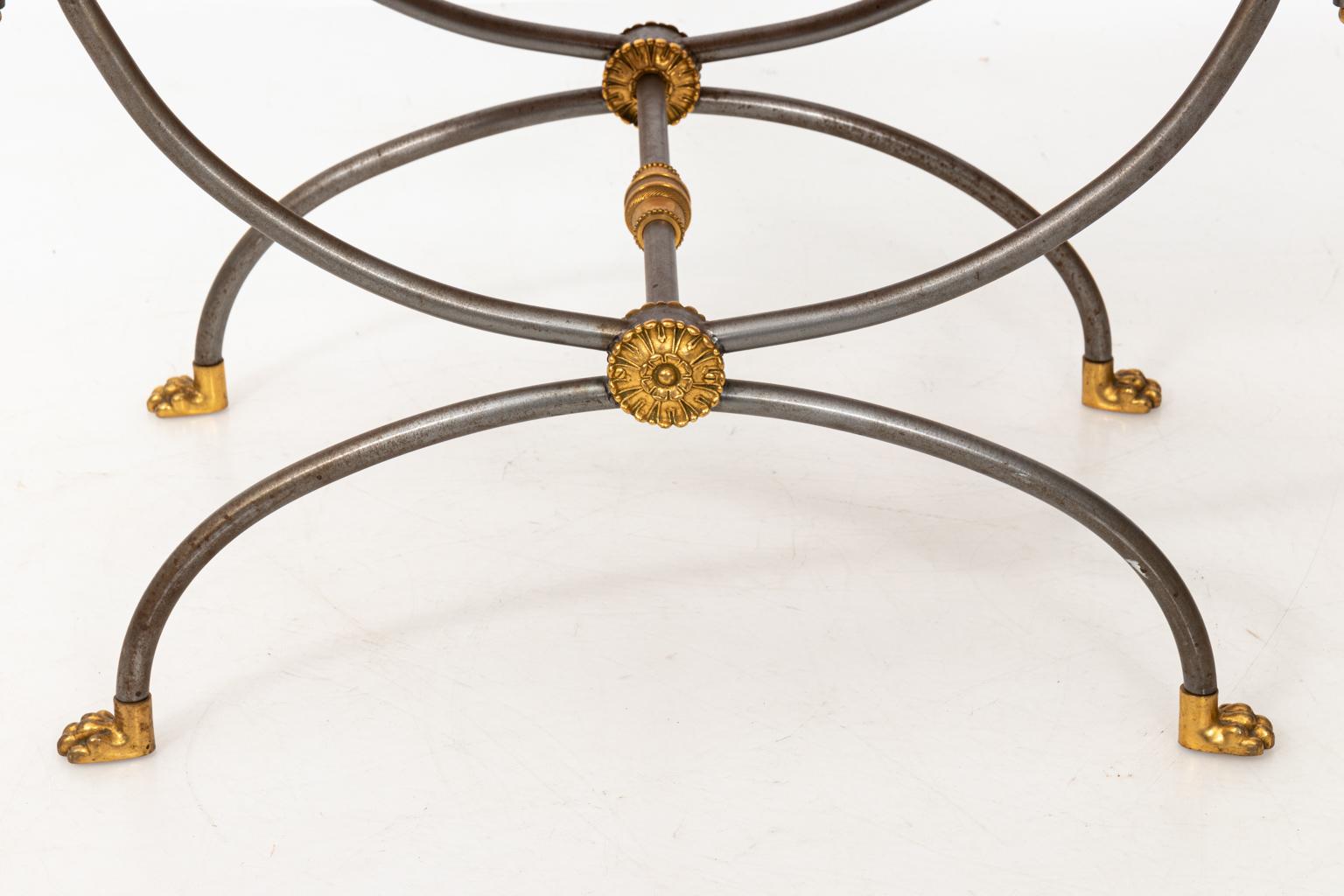 Steel and brass curule form bench in the manner of Maison Jansen with upholstered seat. Please note of wear consistent with age including wear and oxidation to the base.