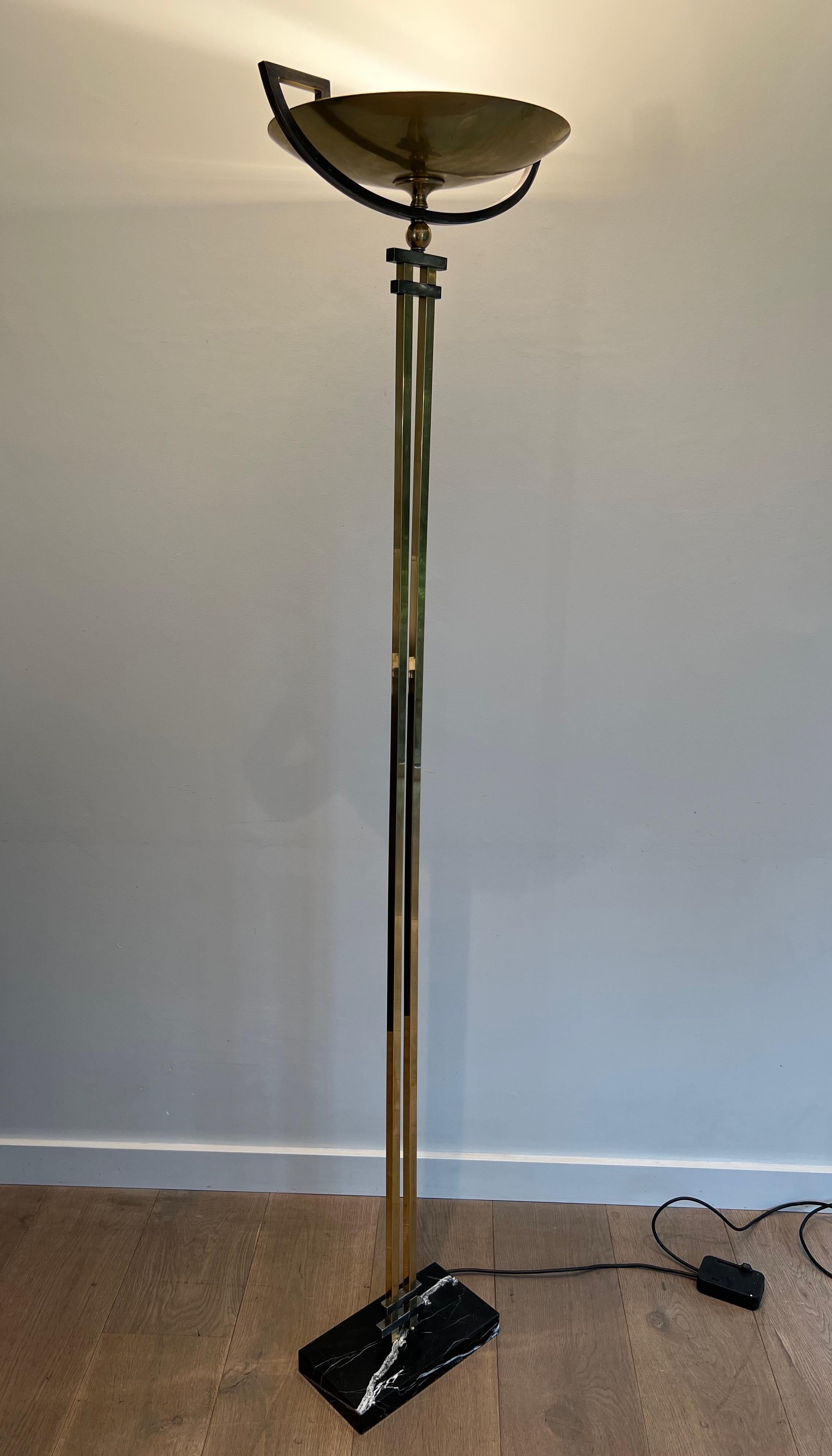 This very nice and stylished floor lamp is made of steel and brass, standing on a black marble base. This is a French work in the style of the Art Deco Period and in the style of the famous Jean Perzel workshops, circa 1970.