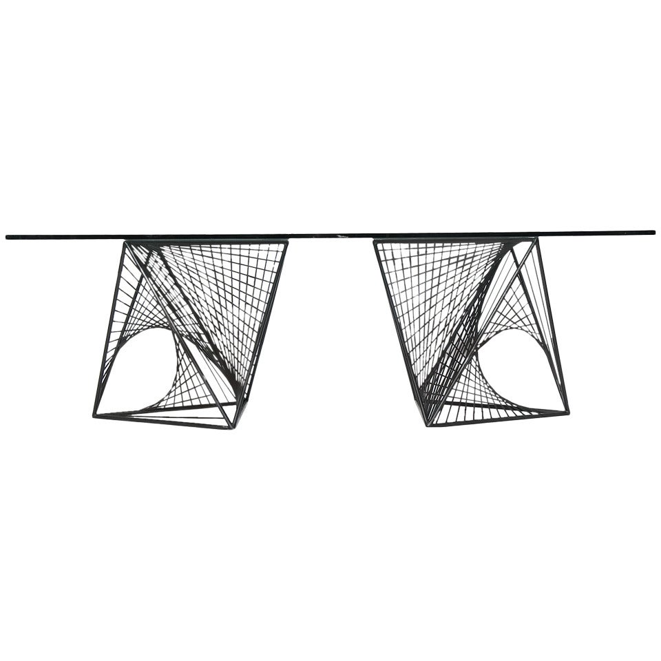 An expressive and well-scaled Mid-Century Modern dining table or console. Table features two geometric, sculptural hand-rendered solid steel forms, patinated in black, supporting a thick rectangular glass top. Made in the USA, circa 1960s.