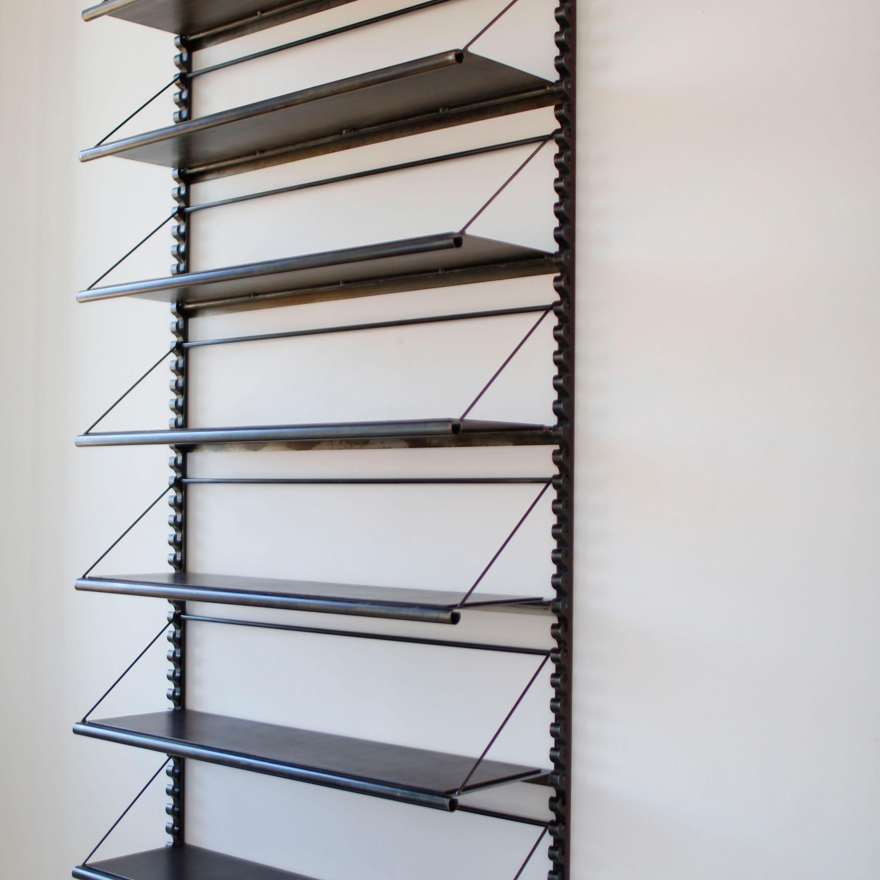Formed sheet metal shelving with welded steel framework, bridle leather detail on shelf top available in a 'dark chocolate' brown or black color. Shelves are created with a structure that lifts from the brackets for adjustability. Very heavy duty