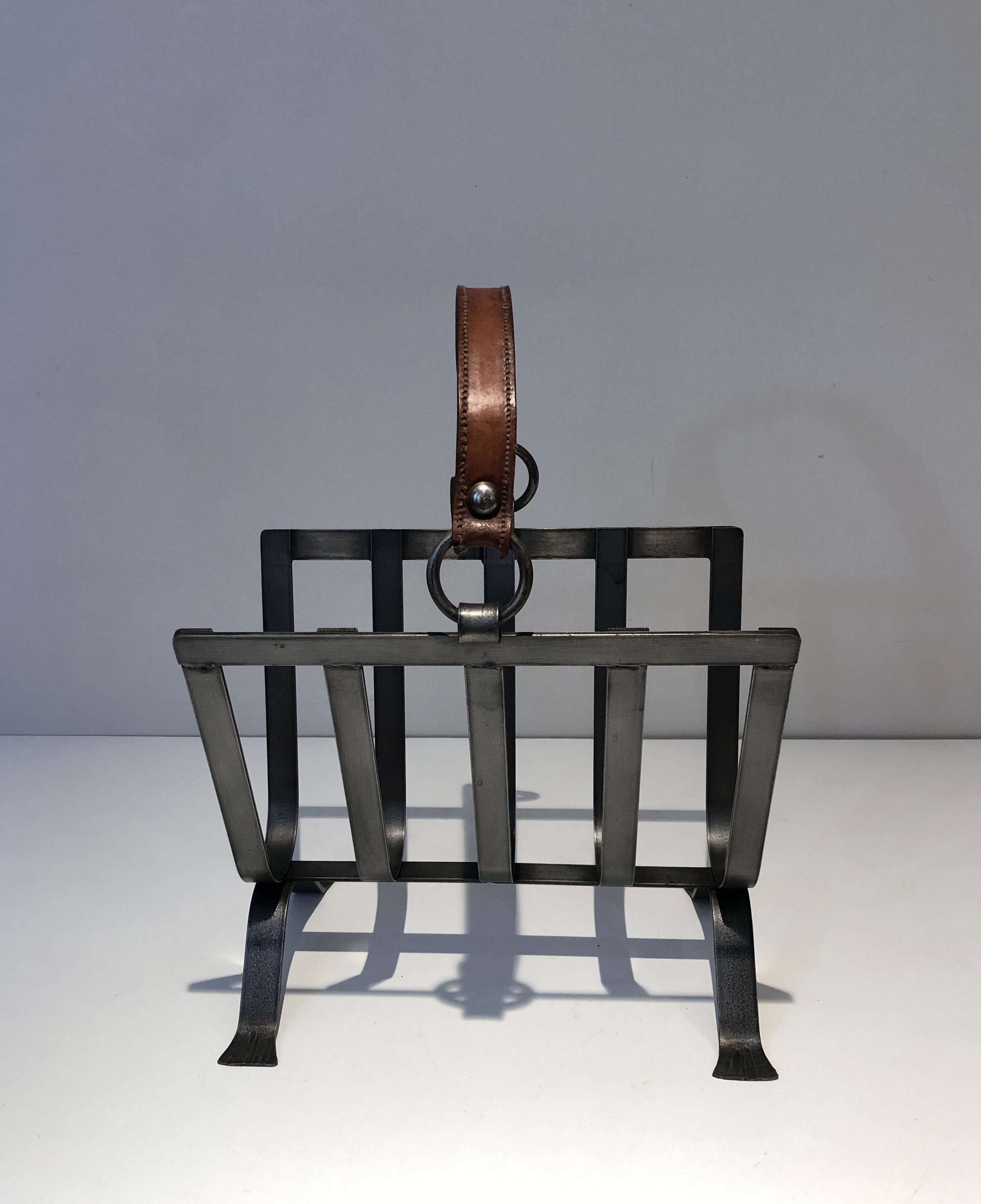 This unusual magazine rack is made of steel and leather. This is a very nice work of great quality. This is a work in the style of famous French designer Jacques Adnet. circa 1950.
