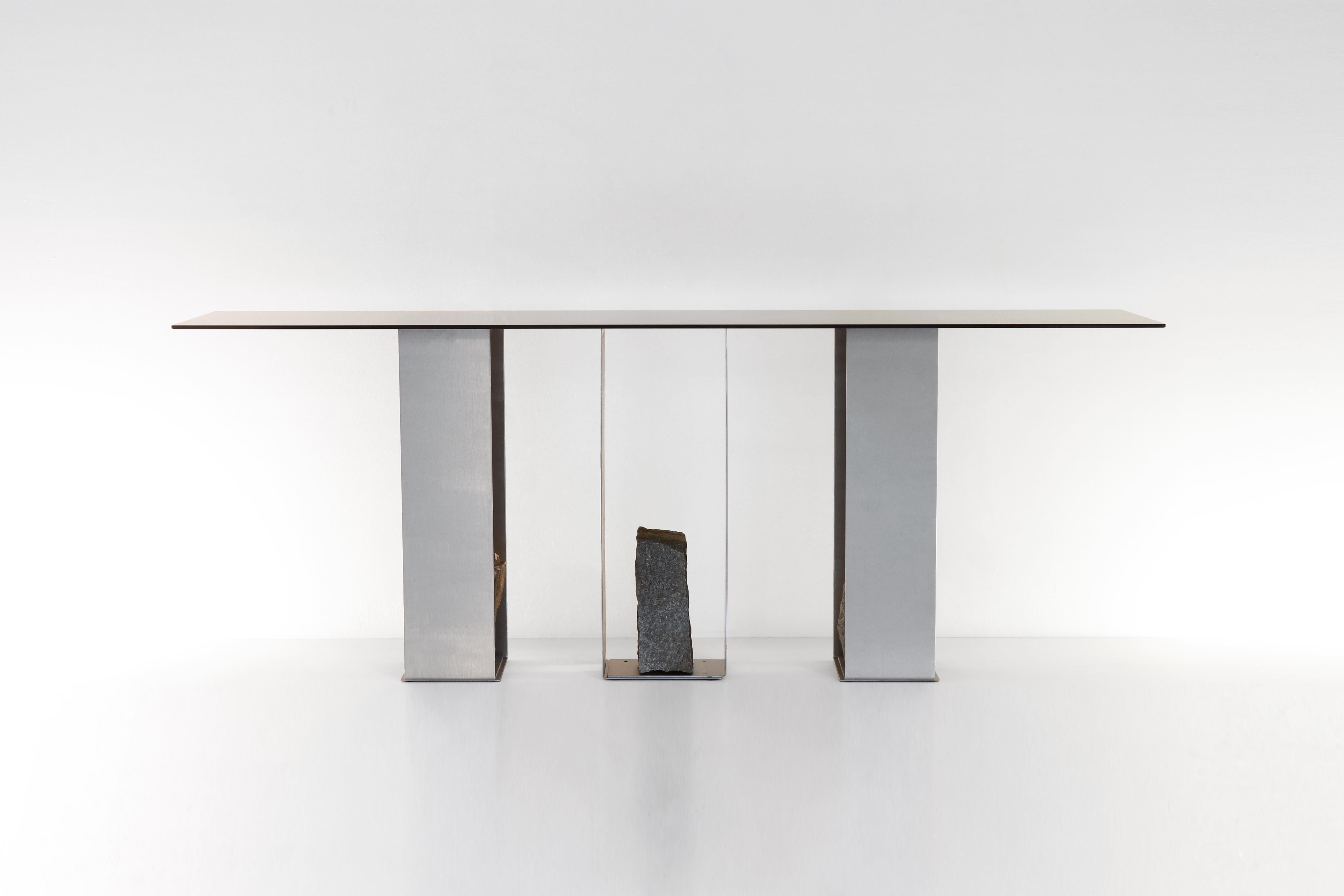 Steel and stone console table by Batten and Kamp
2020
Shelter to Ground Collection
Dimensions: Top: W 190 x D 50 cm
Console base: W 108 x D 24 x H 72 cm
Materials: Hand finished stainless steel, tinted glass, natural stone

Top can be custom to any