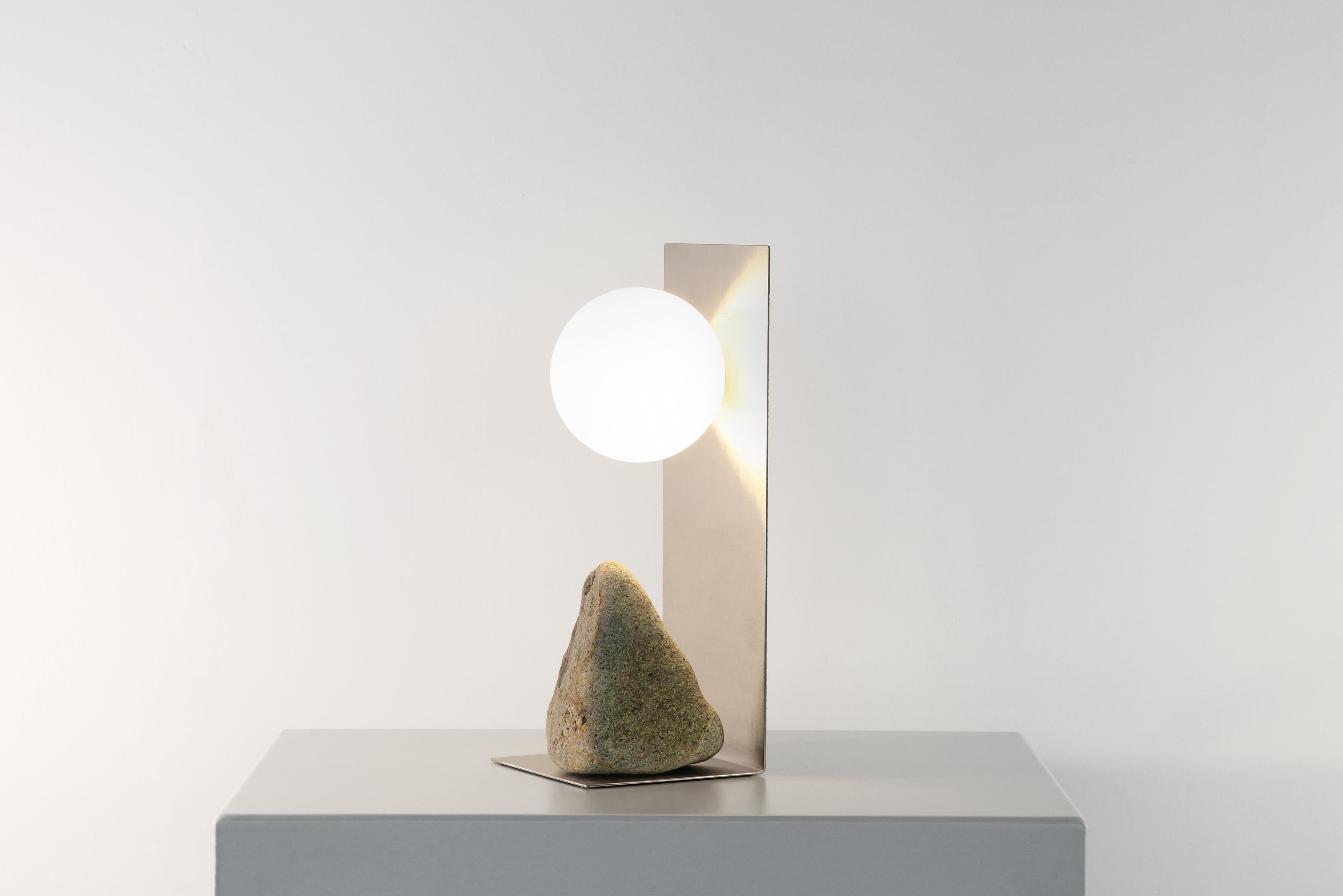 Steel and stone table lamp by Batten and Kamp
2020
Shelter to Ground Collection
Dimensions: W 14 x D 14 x H 33 cm
Materials: Hand finished stainless steel, natural stone and frosted glass
 LED, Electrical components

The stone is different