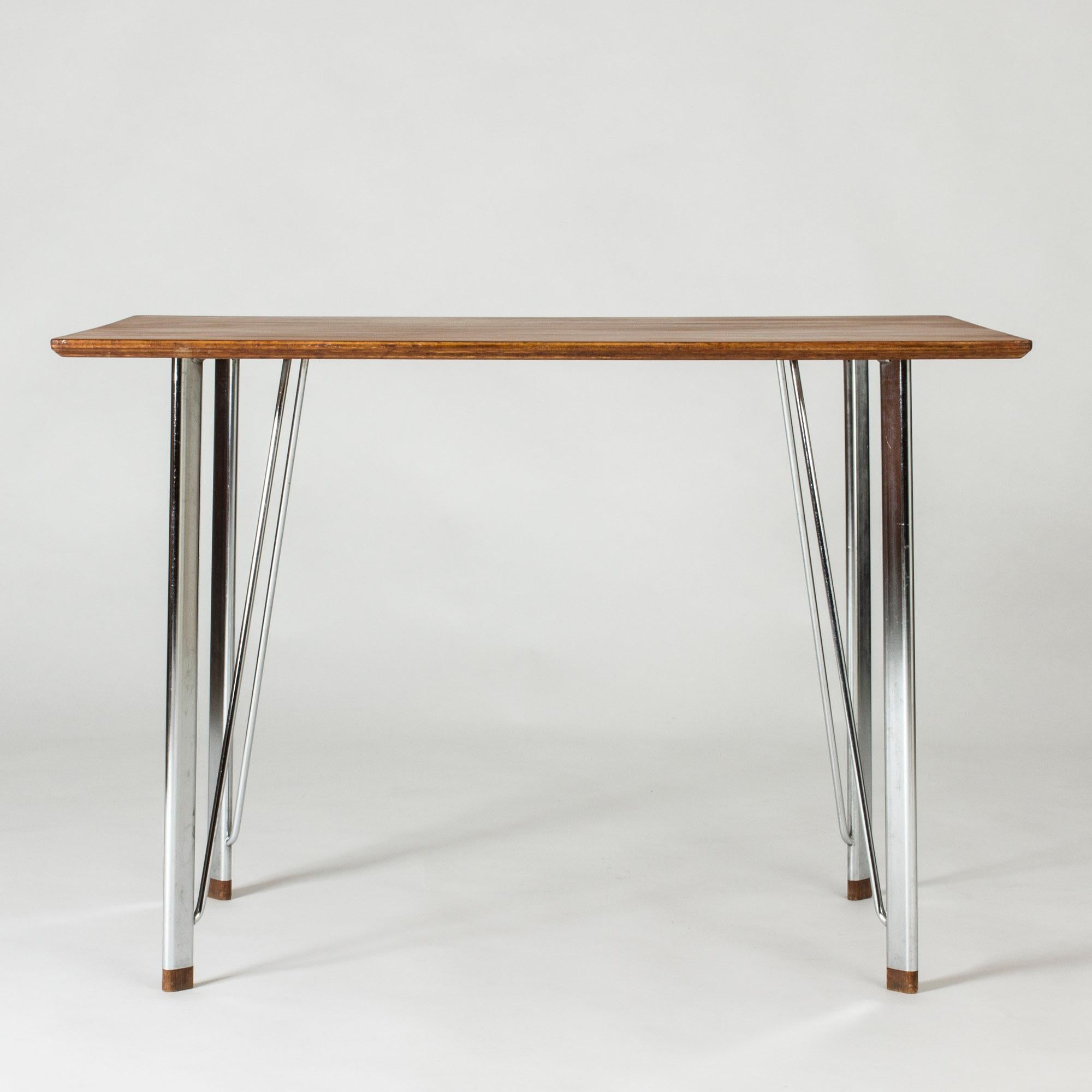 Elegant, minimalist desk by Arne Jacobsen. Sleek steel frame with wooden feet, beautiful teak table top. Neat size.