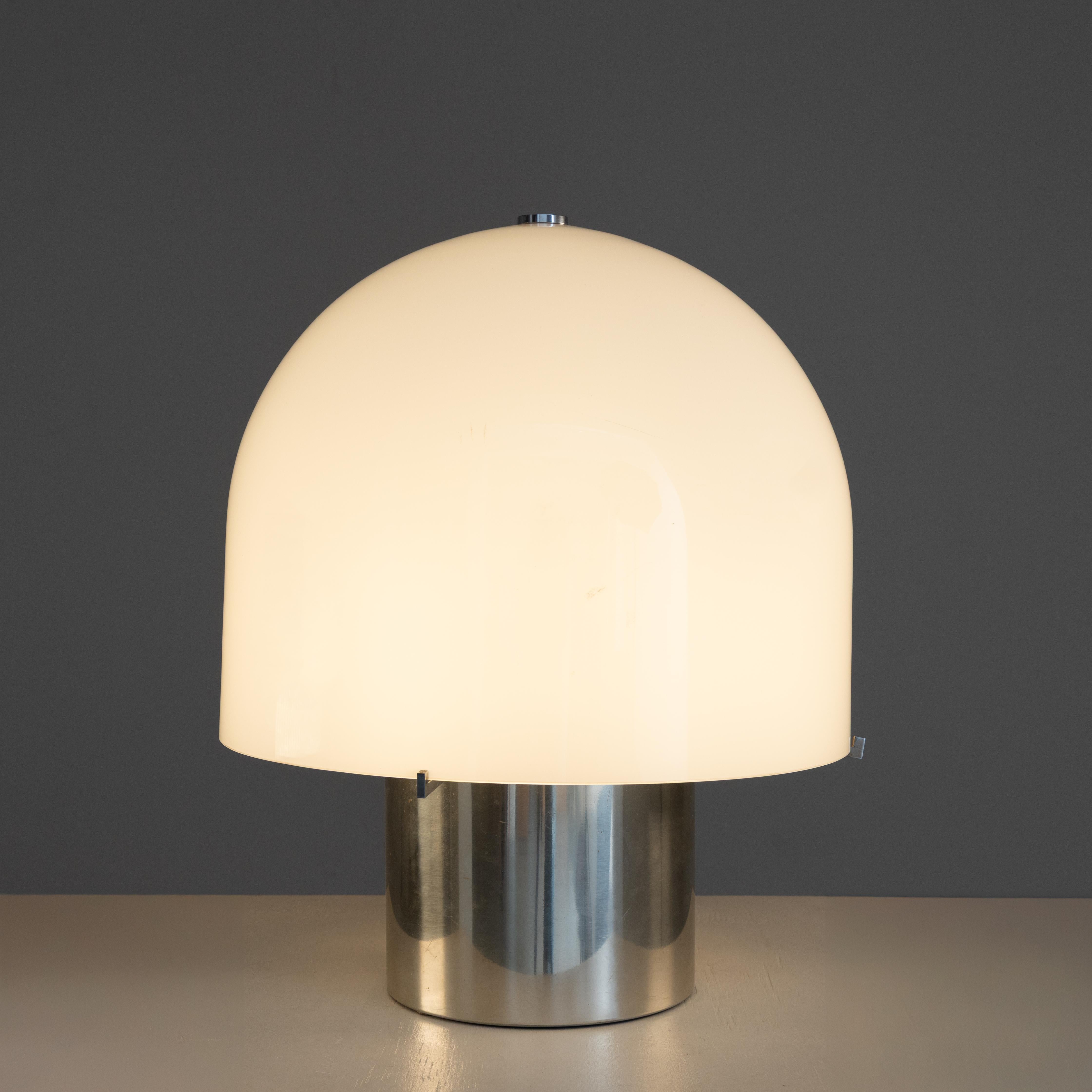 lampe de table de fabrication italienne, réalisée dans les années soixante-dix. La structure en acier poli supporte un diffuseur en verre soufflé, créant un équilibre raffiné entre le matériau industriel et l'artisanat. L'esthétique minimale et