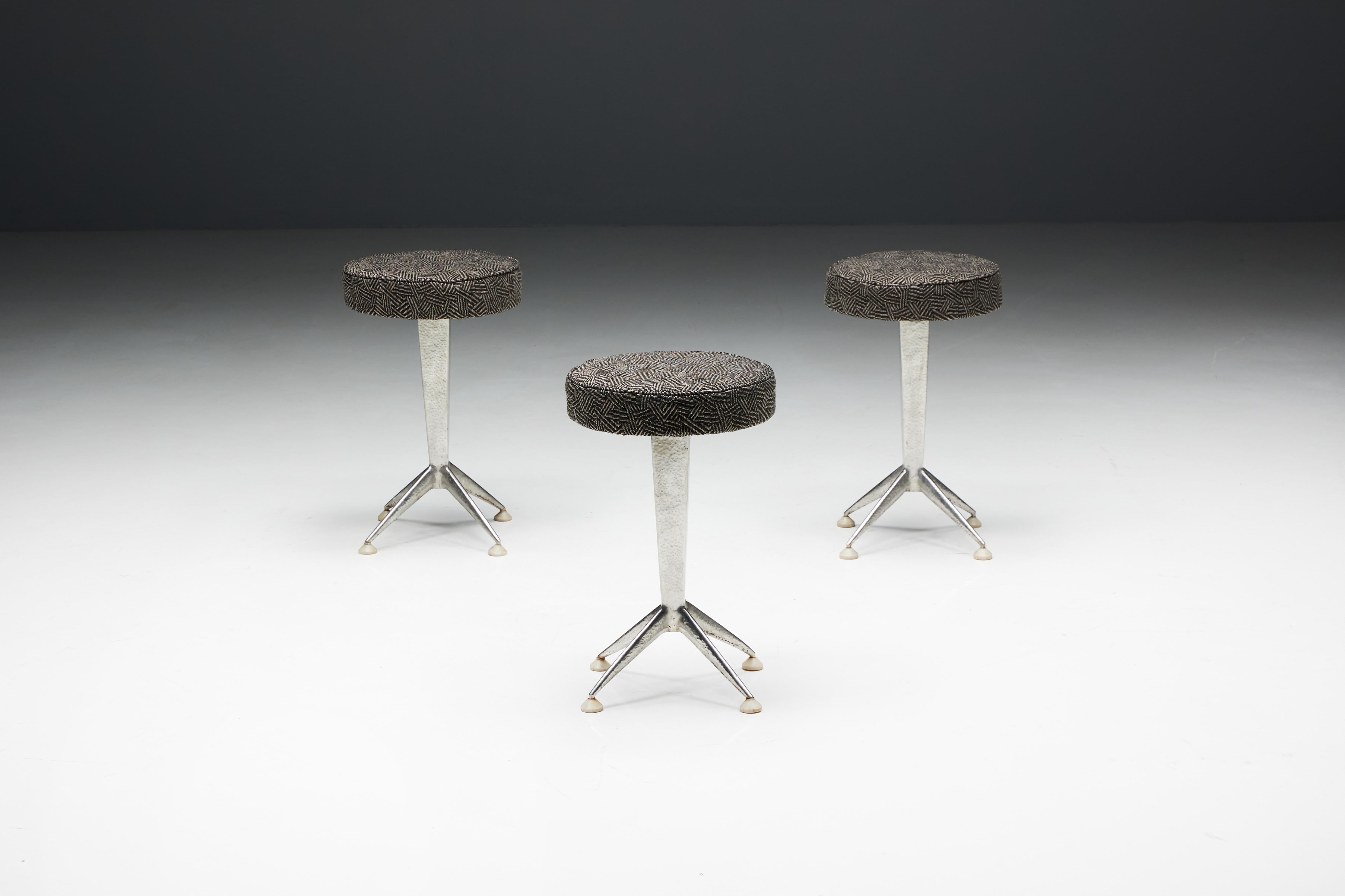 Hammered steel bar stools, inspired by the sleek lines and geometric patterns of Art Deco design. These stools feature round fabric seating in an Art Deco print atop hammered steel legs, embodying the sophistication and glamour reminiscent of the