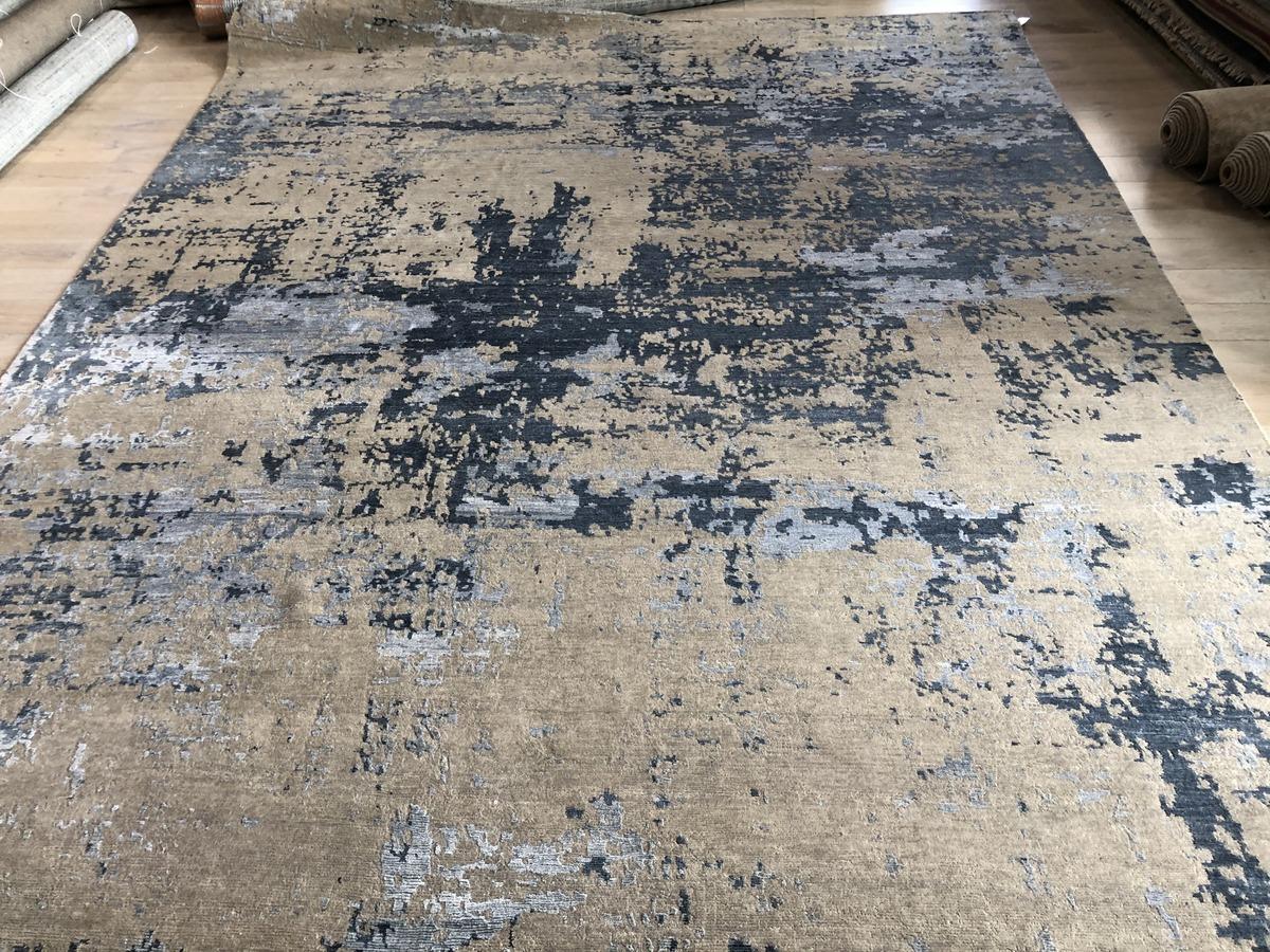 A stunning abstract area rug that is lovely to behold and soft underfoot. Dominant tones are steel blue, beige/ecru and silver. A wool/viscose blend gives it durability with softness and sheen. Hand crafted in India using vegetal dyes.