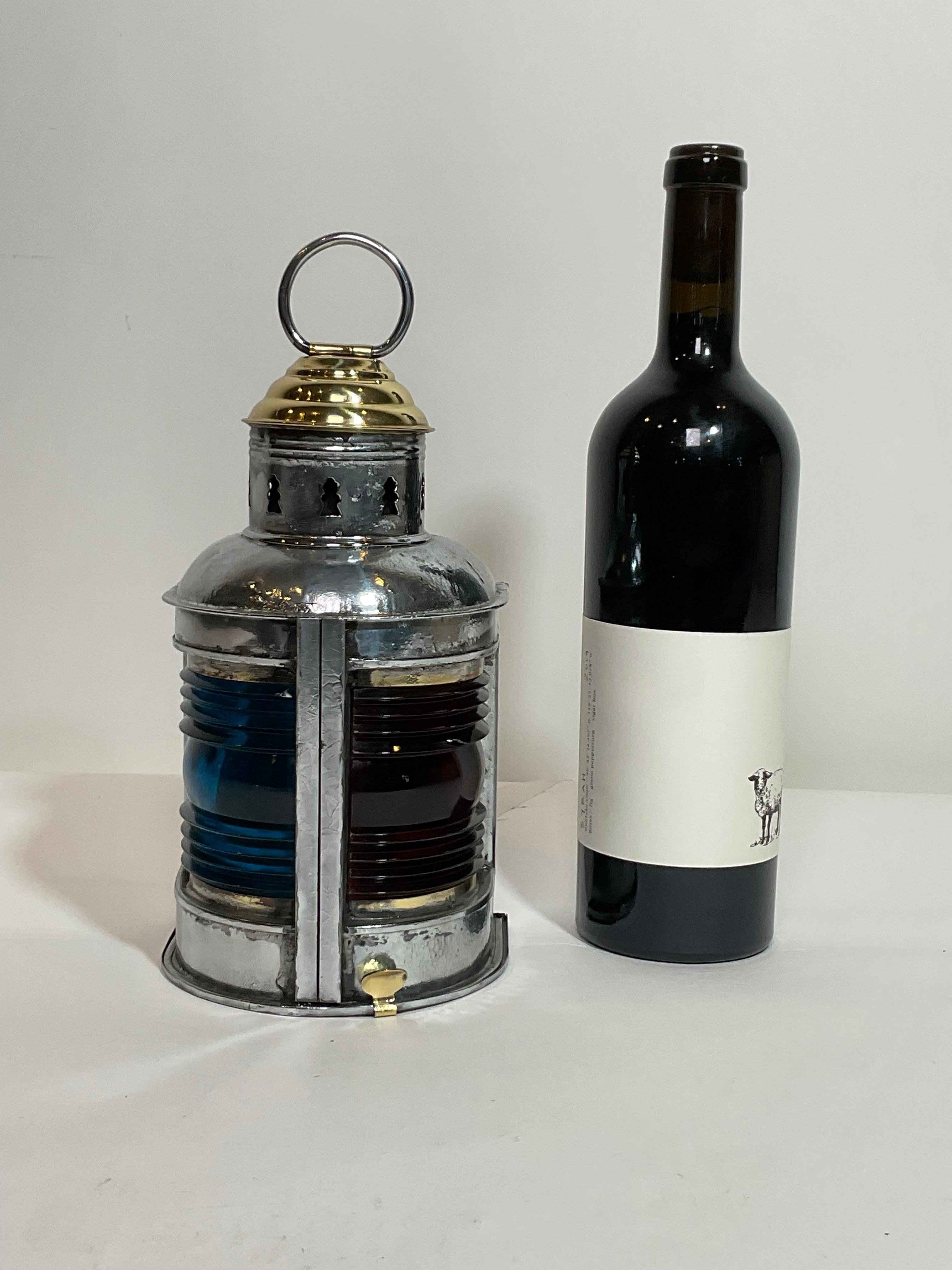 Highly polished and lacquered boat lantern with red and blue Fresnel lenses, with brass vented turret top and carry ring. The case of the lantern is polished galvanized steel with a hinged bottom and removable burner.

Weight:    2 lbs.
Overall