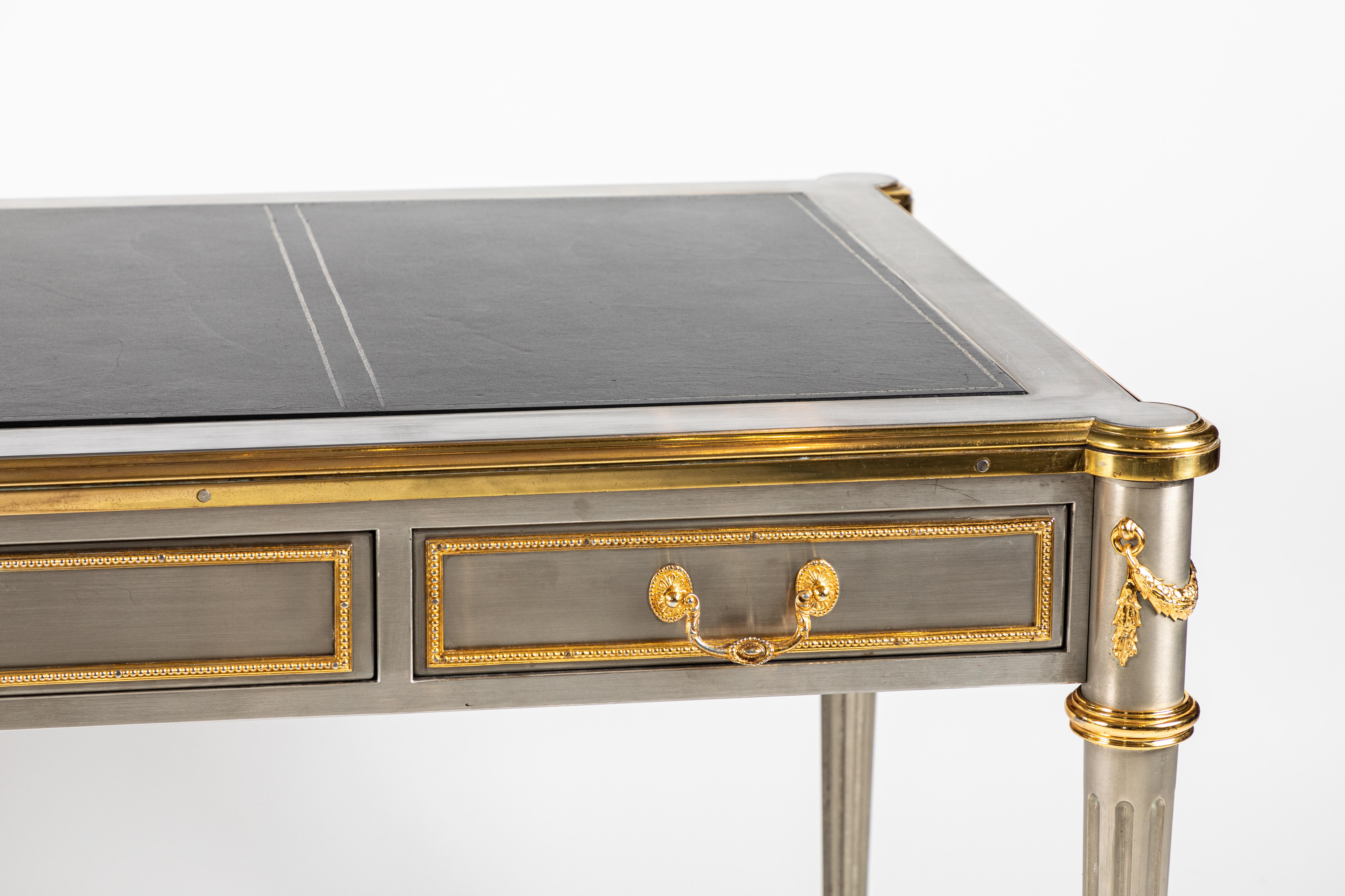 An absolutely fantastic steel desk by John Vesey with bronze doré mounts, and original gold embossed leather top. The desk has three drawers across the front on one side with a key lock on the center drawer including key. This desk came from the