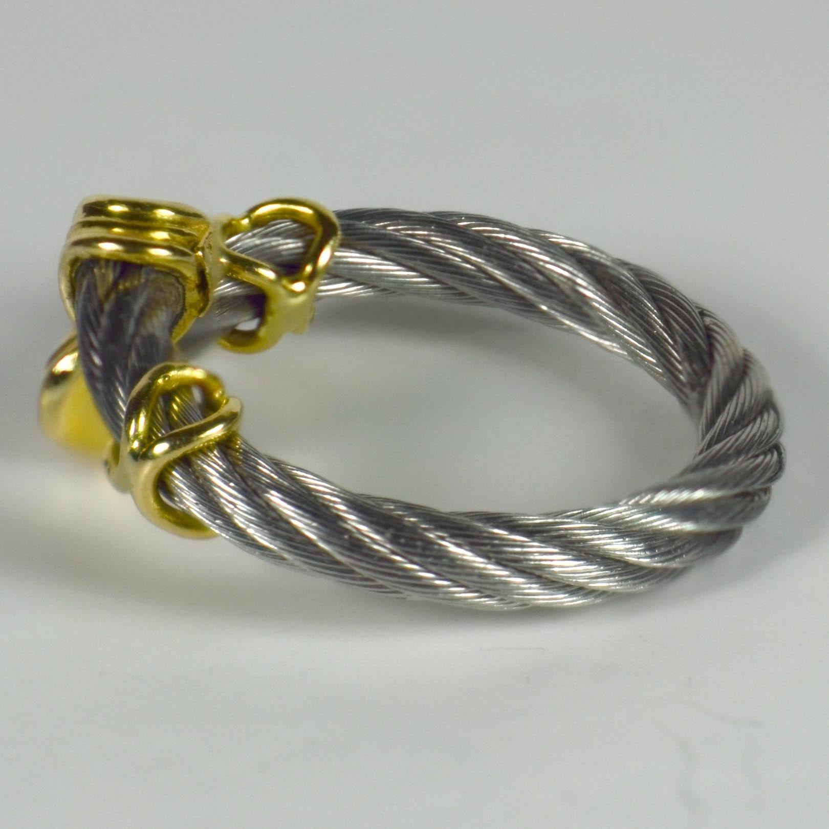 A smart ring in twisted steel cable with 18 karat yellow gold cross-shaped bands and ridged terminals.
Numbered 69503, marked 750 for 18 karat gold.
Ring size 6 (US), L.5 (UK.
