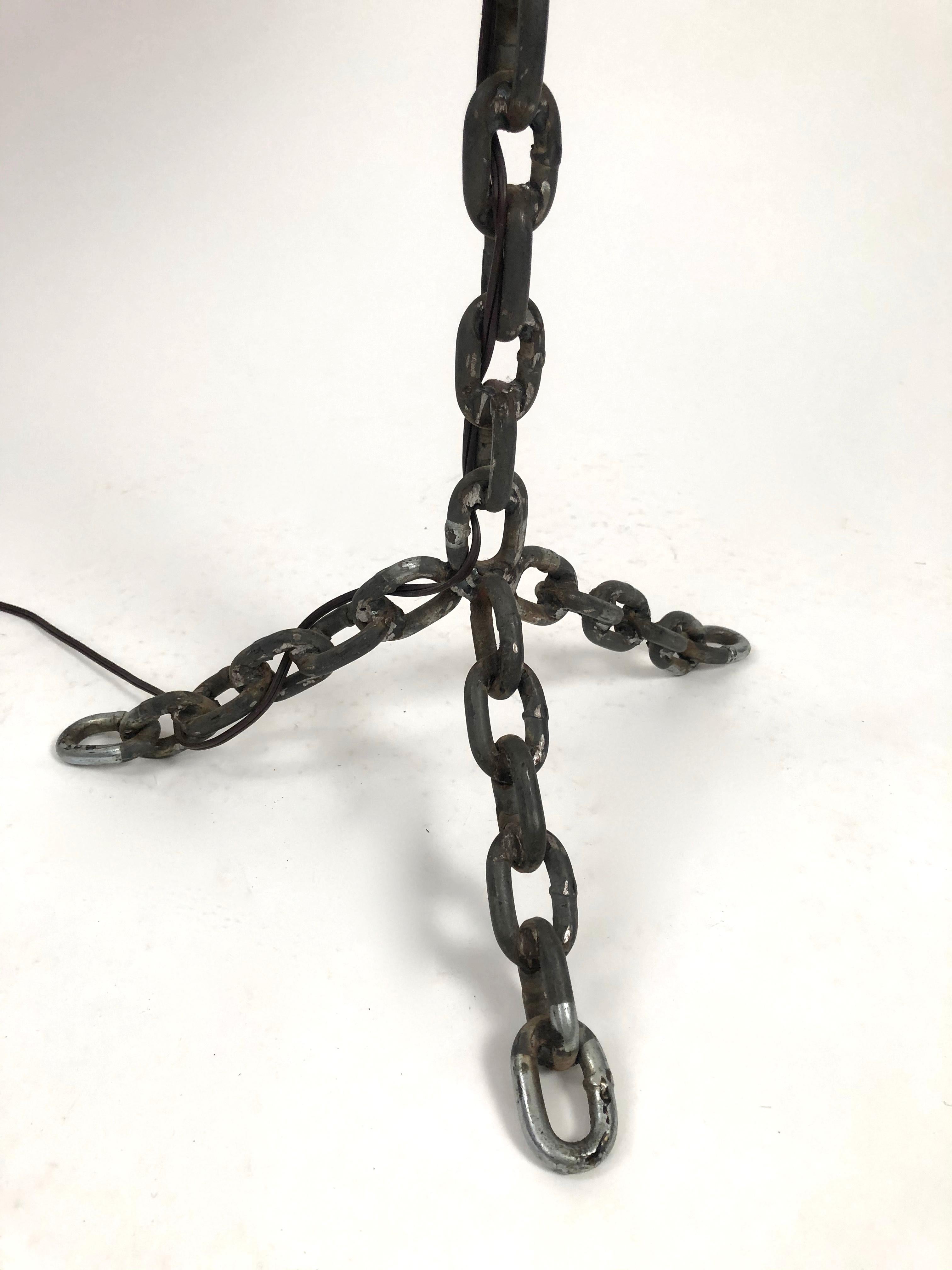 A handmade steel chain link lamp with tripod base and burlap shade. Wonderfully sculptural, both primitive, like folk art, and modern. New shade included, if desired.