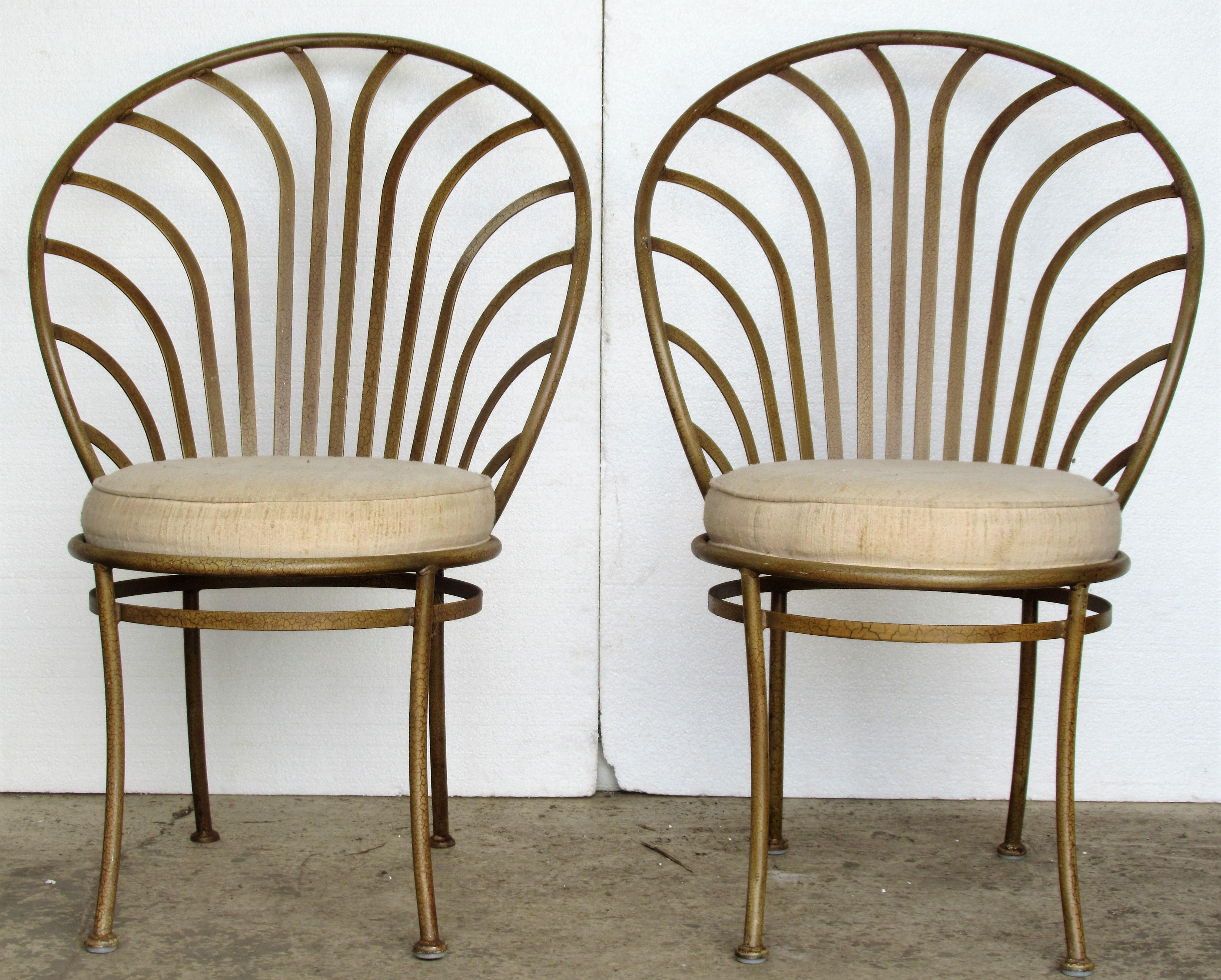 A set of four steel French Art Deco style sculptural scallop back chairs designed by Arthur Umanoff for Shaver Howard with vintage upholstered seats and beautifully aged bronzed gold alligatored painted finish, circa 1970. Look at all pictures and