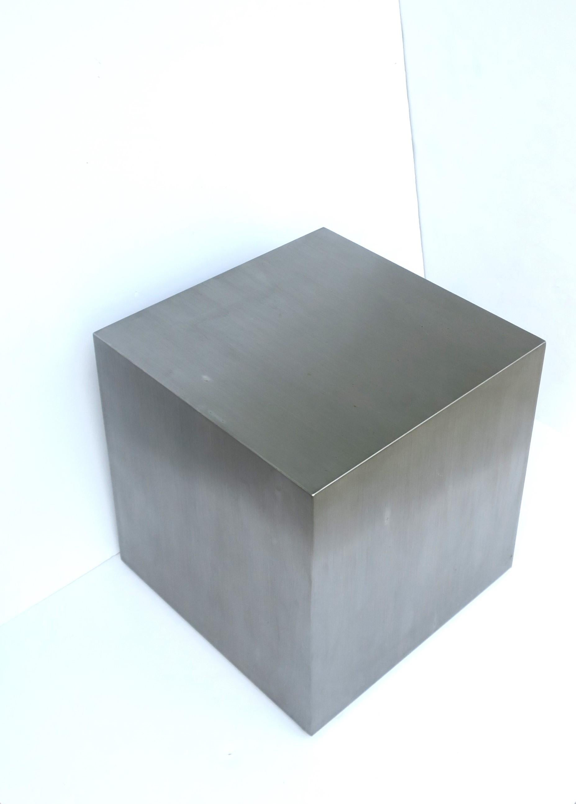 A brushed steel cube pedestal end table in the Minimalist style, circa late-20th century. Table is a brushed silver steel in a square cube form. Great as an end table, side/cocktail table, or to hold/display sculpture, books, etc. Dimensions: 15.69