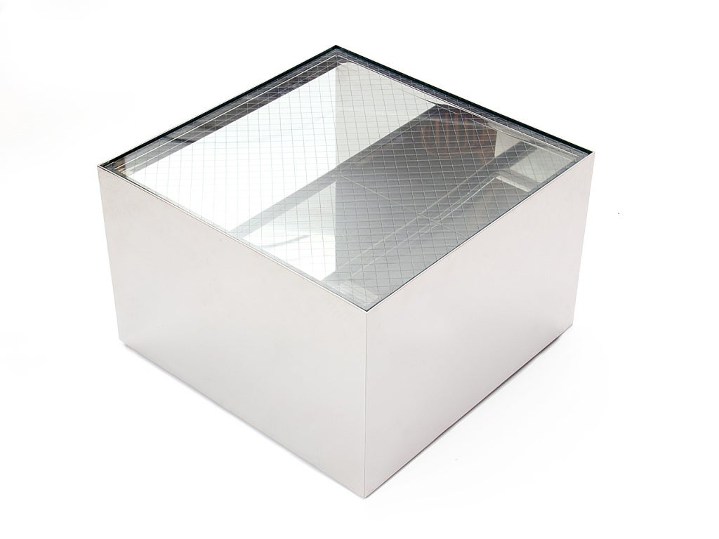 Une table cubique en acier inoxydable conçue par Joe d'Urso. La table repose sur des roulettes encastrées et son plateau est en verre de sécurité. Produit par Knoll aux États-Unis, vers les années 1970.