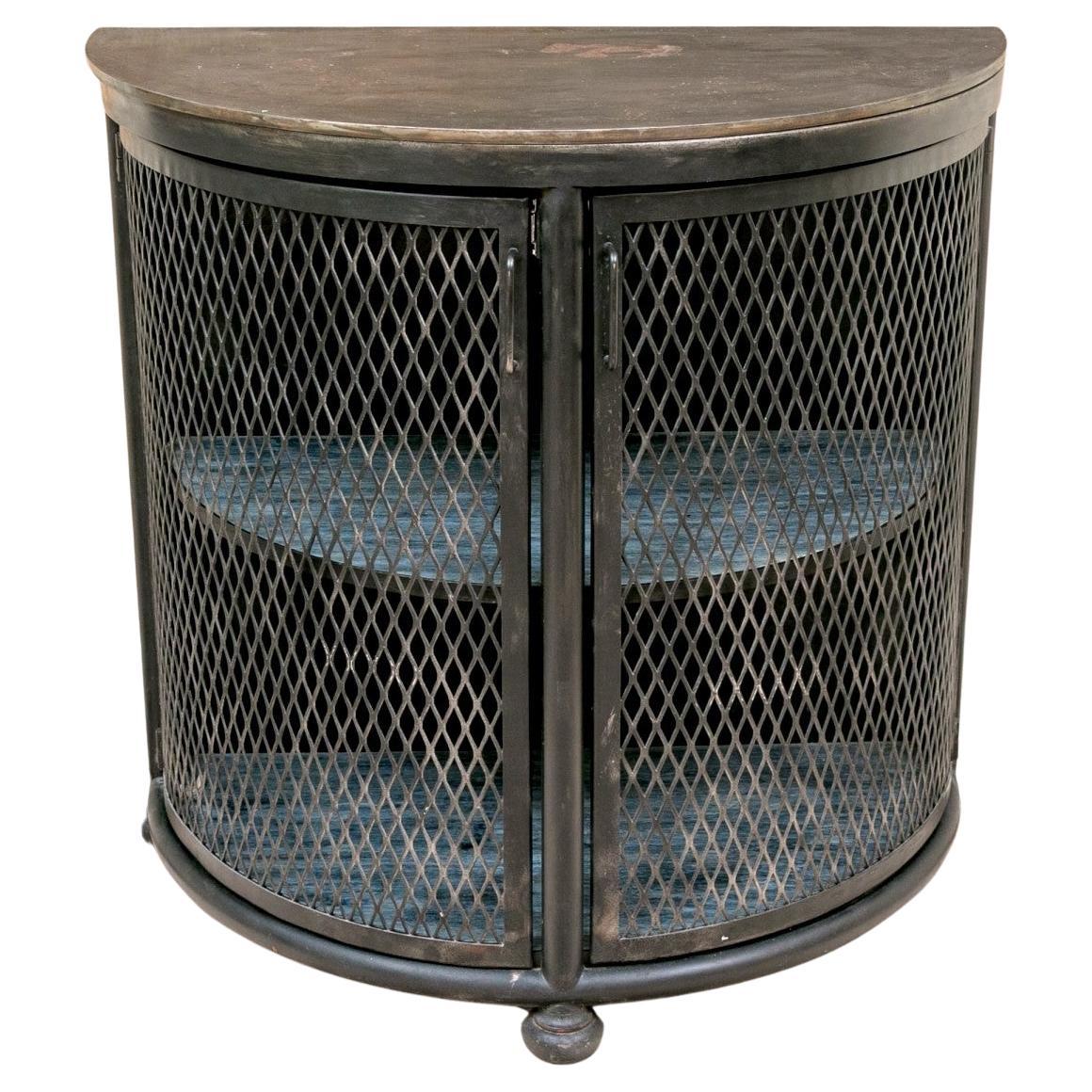 Stunning Custom Steel Demi-Lune Cabinet or console with mesh doors, two interior wood shelves and three bun feet.  The doors pull open to reveal the shelves. Unique piece that can be mixed with a variety of decors.  
Industrial chic with a French