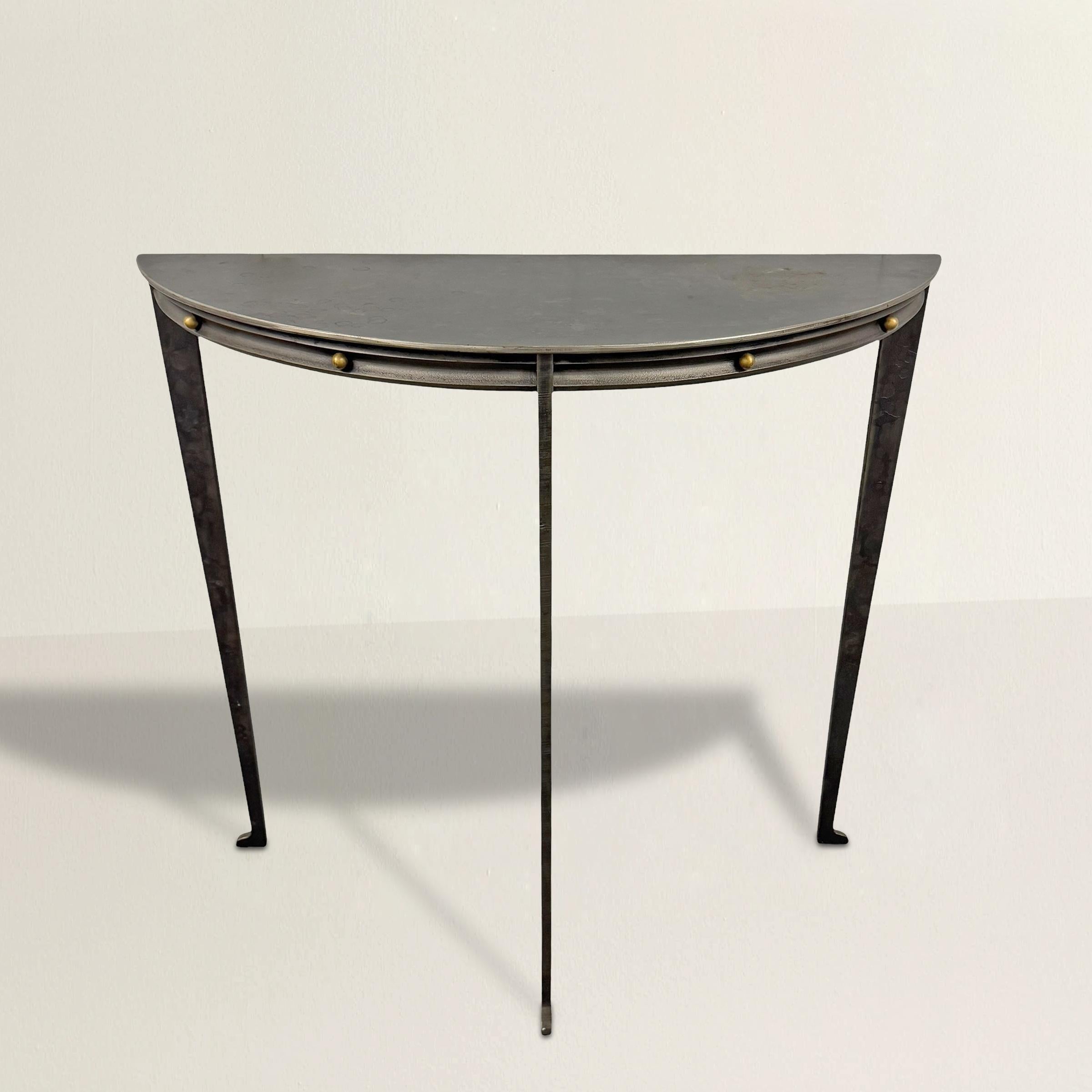A striking example of Postmodern elegance, this chic demilune table designed by Will Stone effortlessly combines clean lines with unexpected details. Constructed from solid steel, its compact half-moon form is enhanced by a precisely executed cove