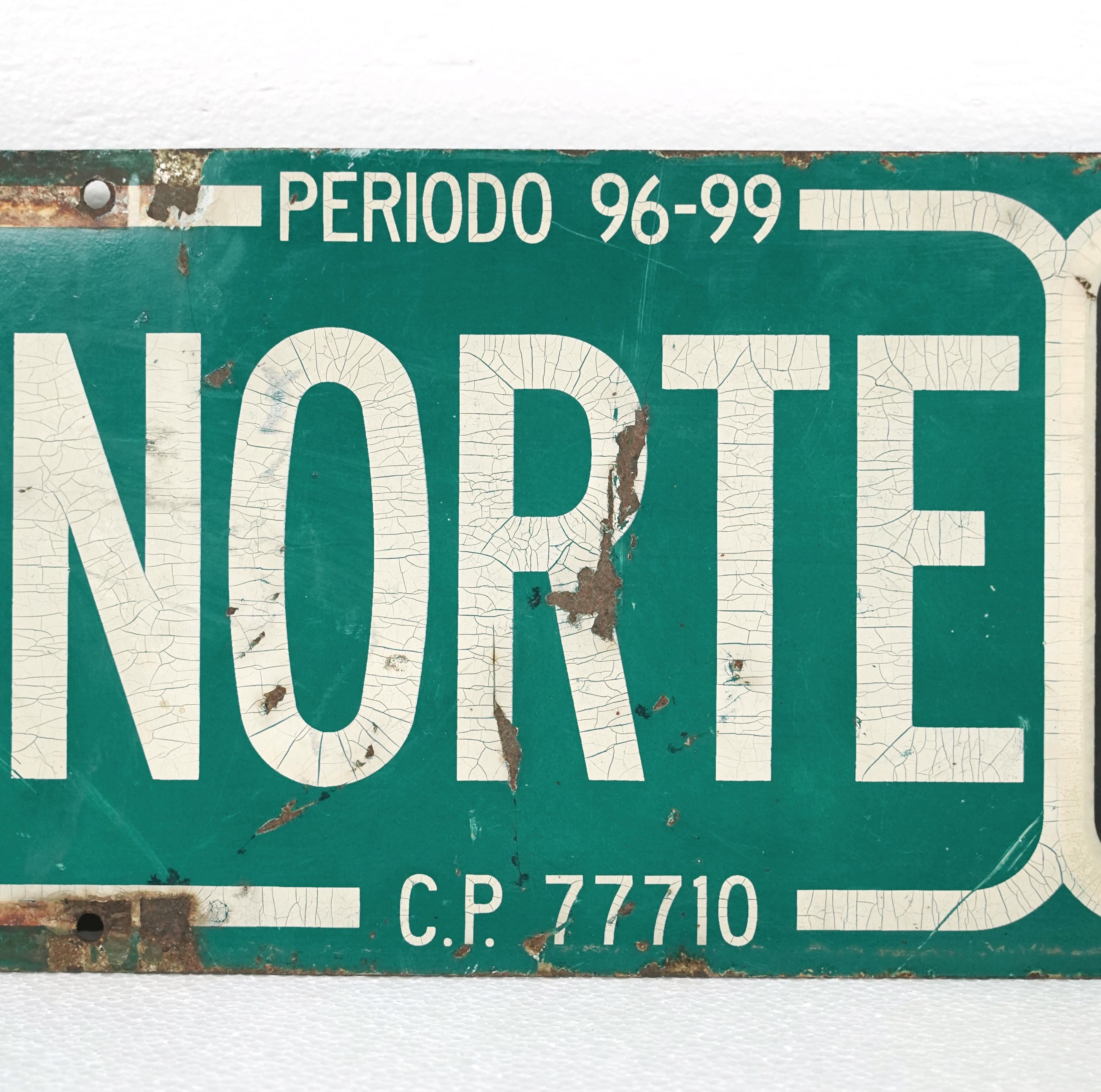 Double sided street sign made of steel in a green, black, and white color. The sign displays 