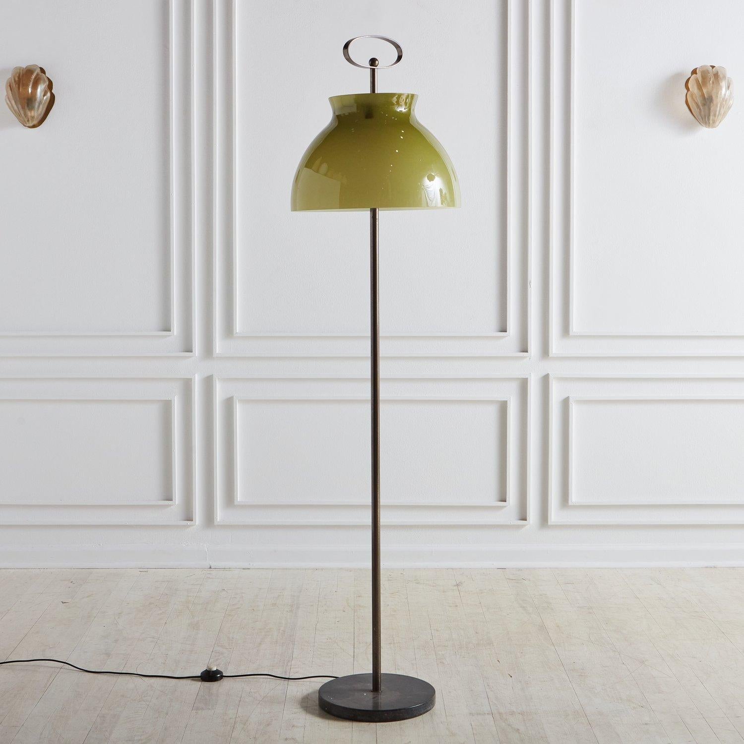 A vintage floor lamp featuring an oversized olive green glass shade and a sculptural oval finial. This lamp has a sleek patinated steel body with a round black marble base. Sourced in Italy, 1970s.

 Measures: 66” Height x 12” Diameter base; glass