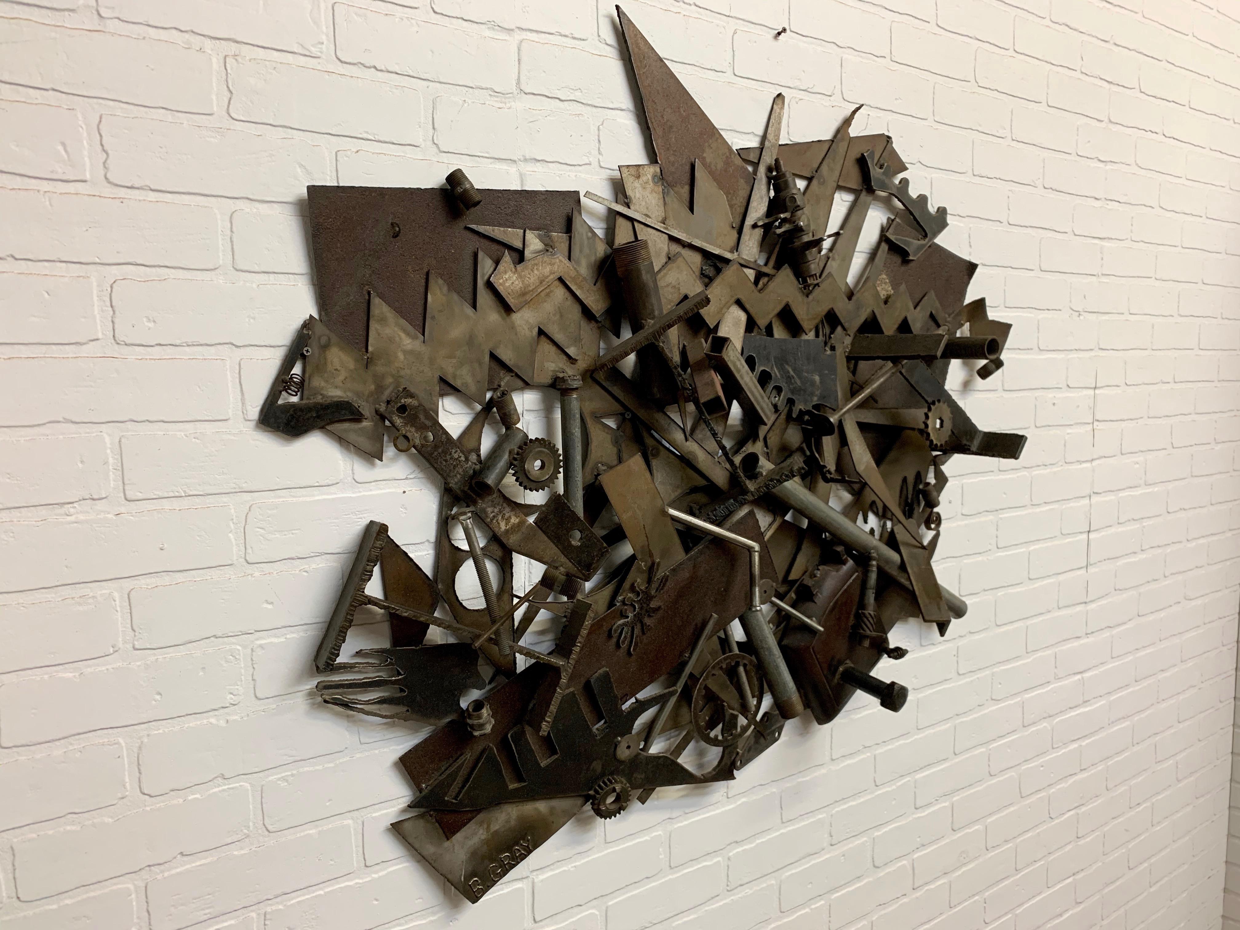 Eine Mischung aus Schrauben und Muttern, Schrott und Zahnrädern, die zu dieser brutalistischen Skulptur zusammengeschweißt wurden, ist ein echter Hingucker. 
Bruce Gray ist für seine Kunst in vielen Museen und Privatsammlungen bekannt.