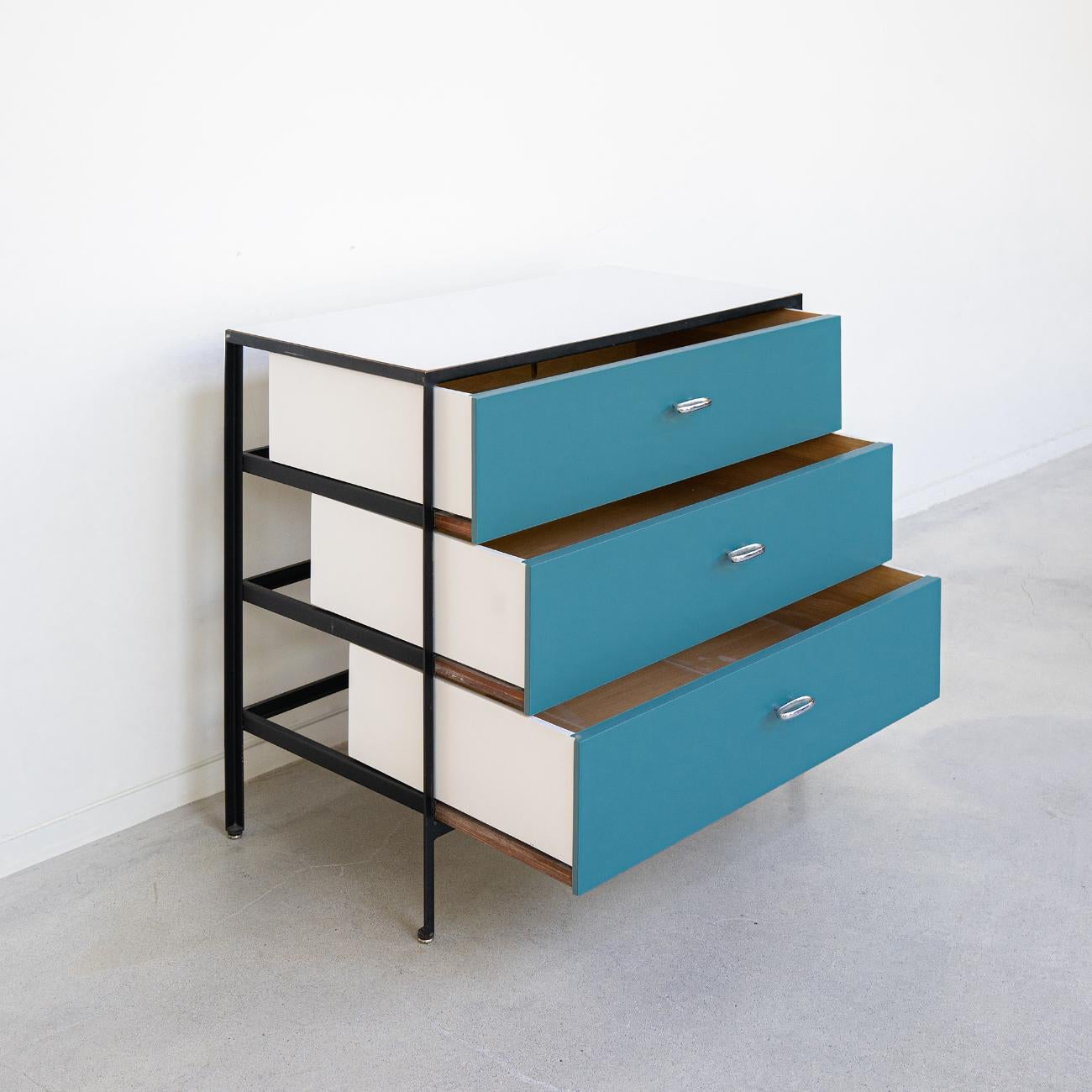 This is a sold dresser designed by George Nelson Associates for Herman Miller dating back to the 1950s. It has three drawers suspended in a steel frame. This unusual design reveals the space behind the drawers when they are opened.

The drawer faces