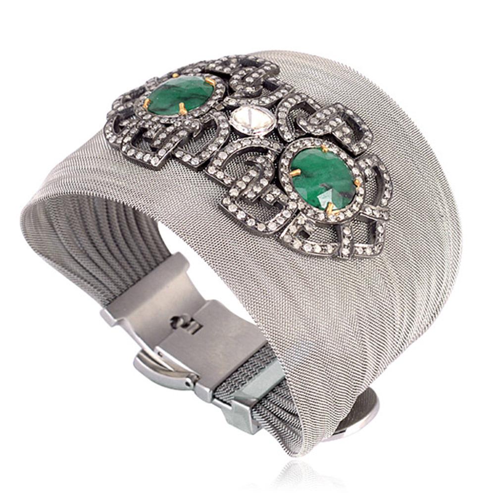 Super chic looking this hand crated silver designer motif with  two round faceted emerald and diamonds around on steel grey mesh bracelet looks smart and edgy. The size can be adjusted as the mesh has 3 hole strap.

Closure: 3 hole hook

18kt: