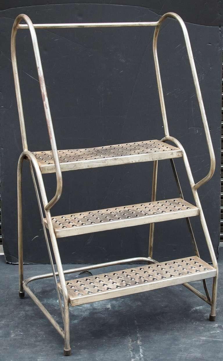 An English industrial step ladder of sturdy steel construction. 
Each step has perforations making a nice tiered plant stand
Great little step ladder for many interior uses - a great pantry or library ladder!