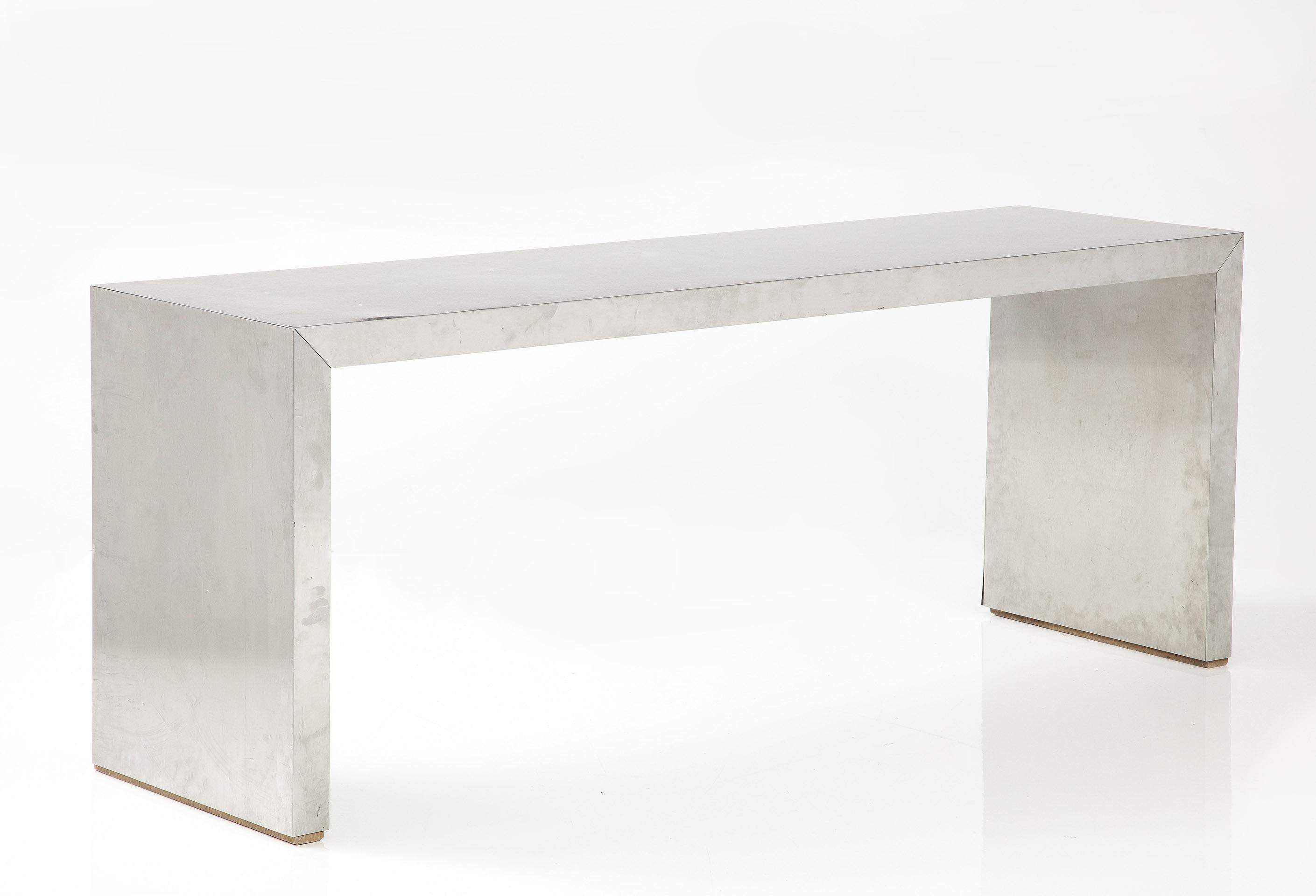 The parsons form console with a brushed steel clad surface and finished on all sides.