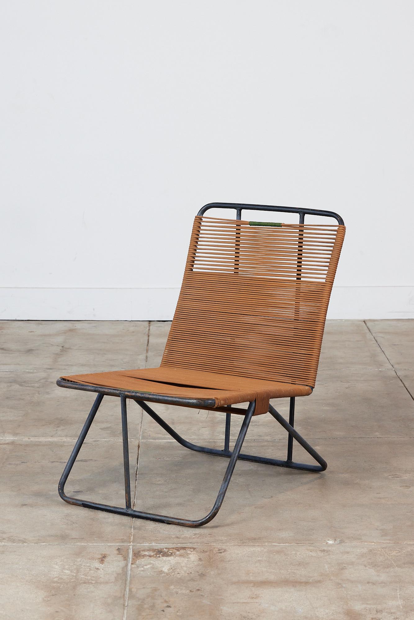 A low lounge chair in the style of Walter Lamb for Brown Jordan.  This chair features a minimal tubular steel frame and caramel brown roping along the seat and backrest. The roping is finished with a green cord detail at both the top of the backrest