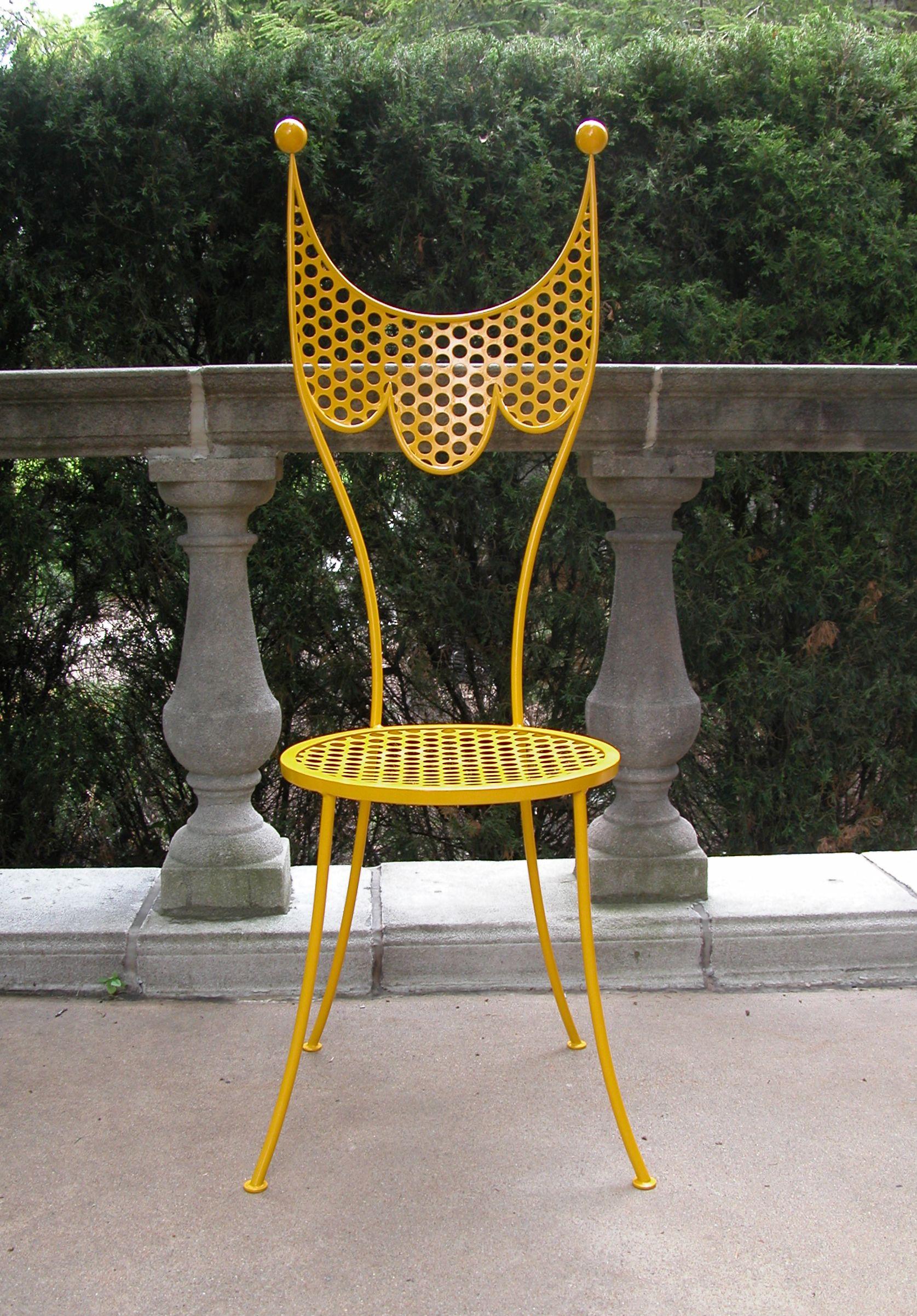 Steel side chair with perforated steel seat and back circa 1950s. In a fresh coat of bright yellow paint. A pair of wooden balls rest atop each back support. 